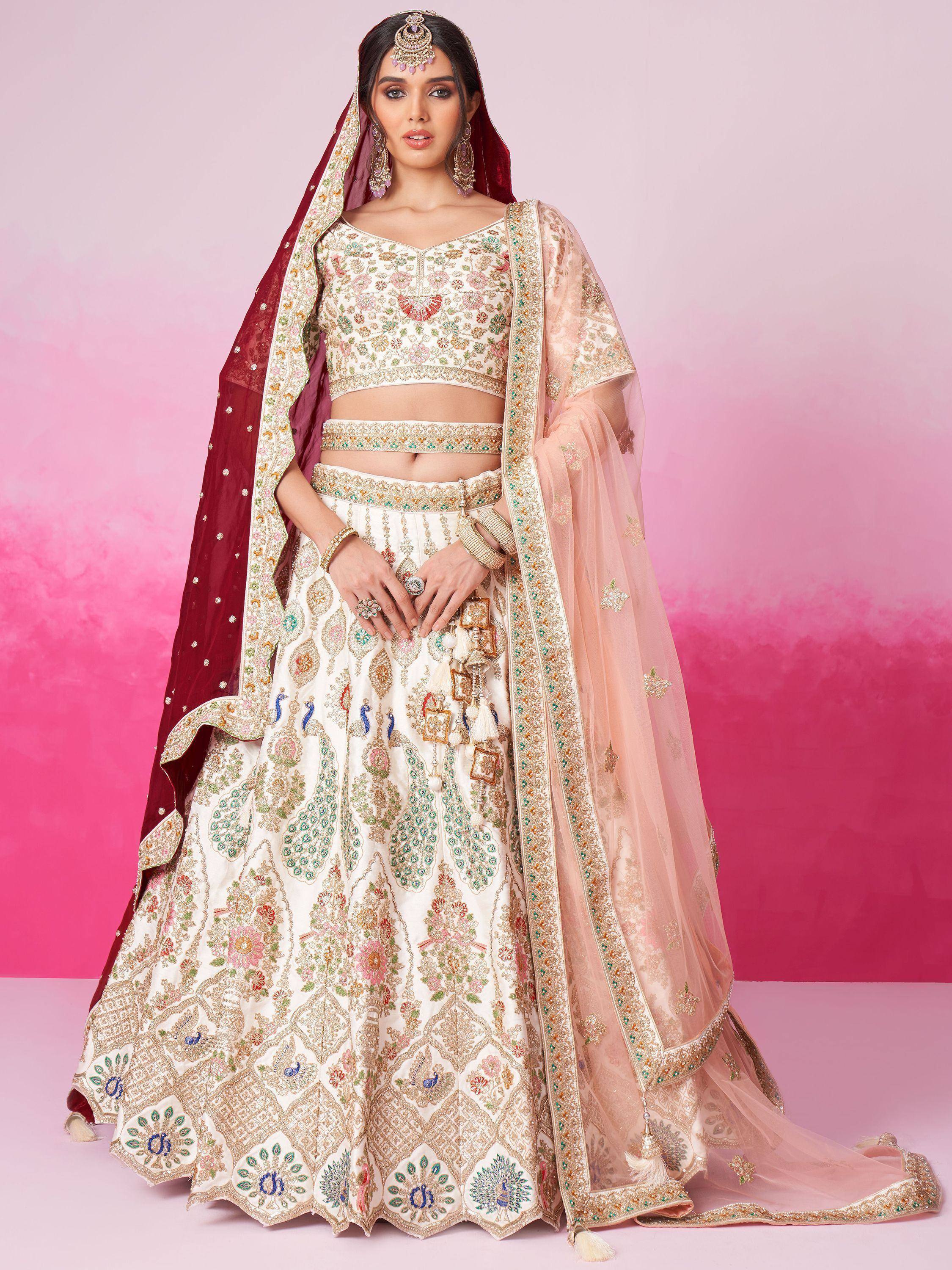 Elegant ivory lehenga choli with floral and peacock embroidery, paired with maroon and blush dupattas for weddings.
