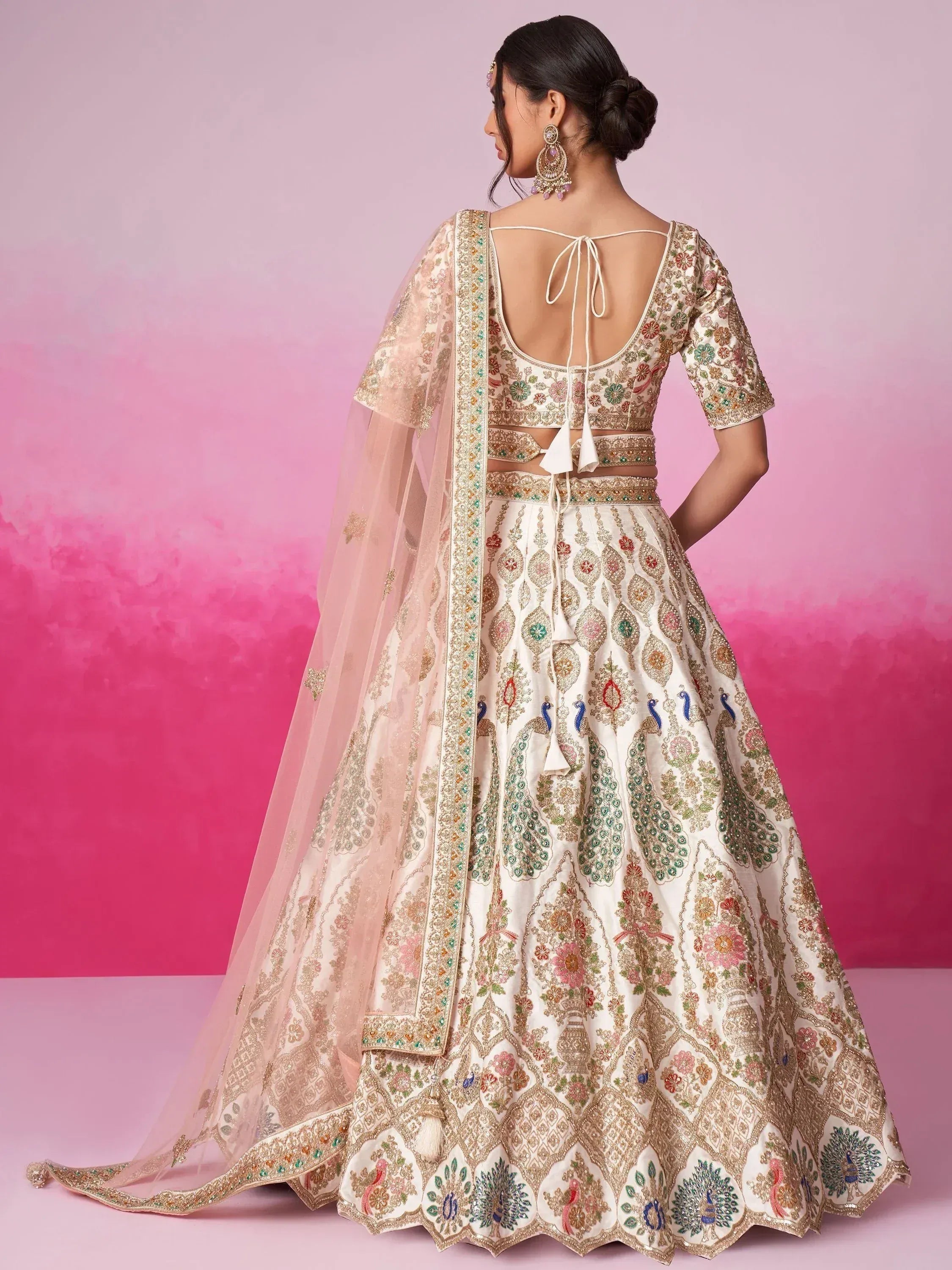 Elegant ivory lehenga choli with peacock embroidery, floral motifs, and sheer dupatta for Indian ethnic wear