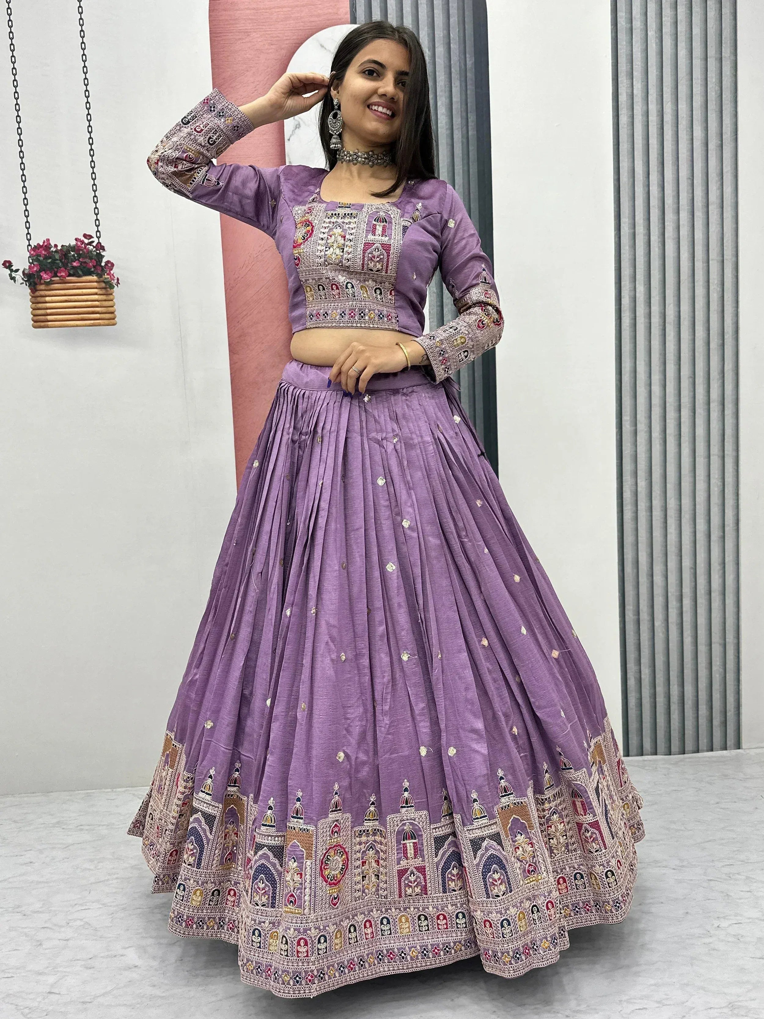 Purple embroidered lehenga choli with intricate mirror work and temple motifs, perfect for Indian ethnic occasions.