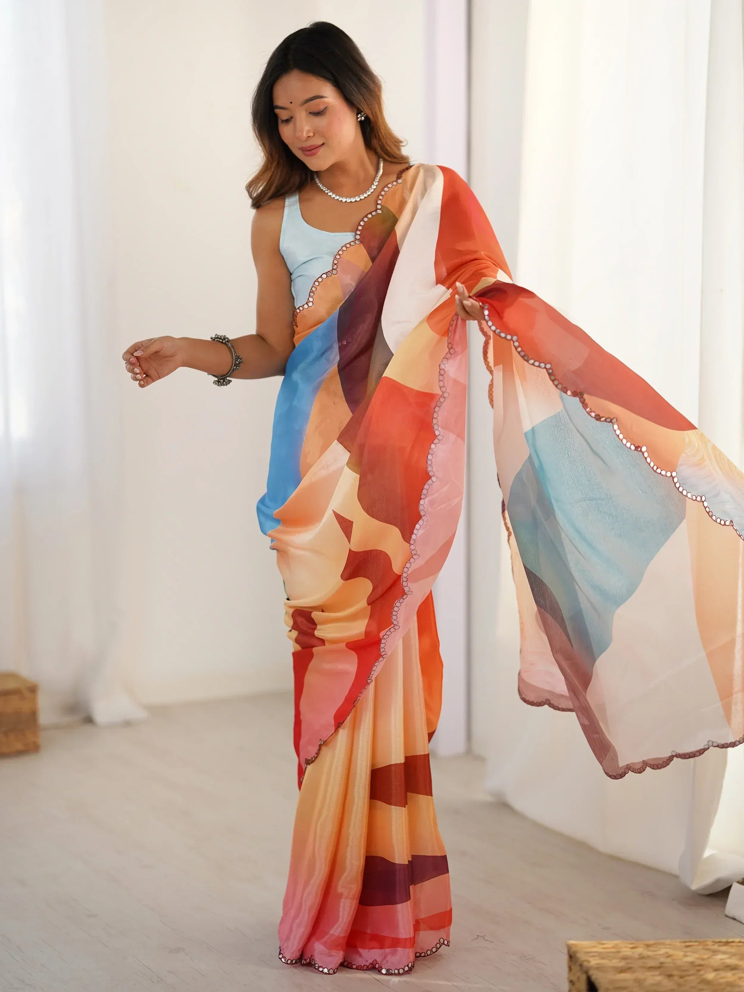 Woman in colorful printed saree with sequin border, ethnic Indian wear for festive occasions