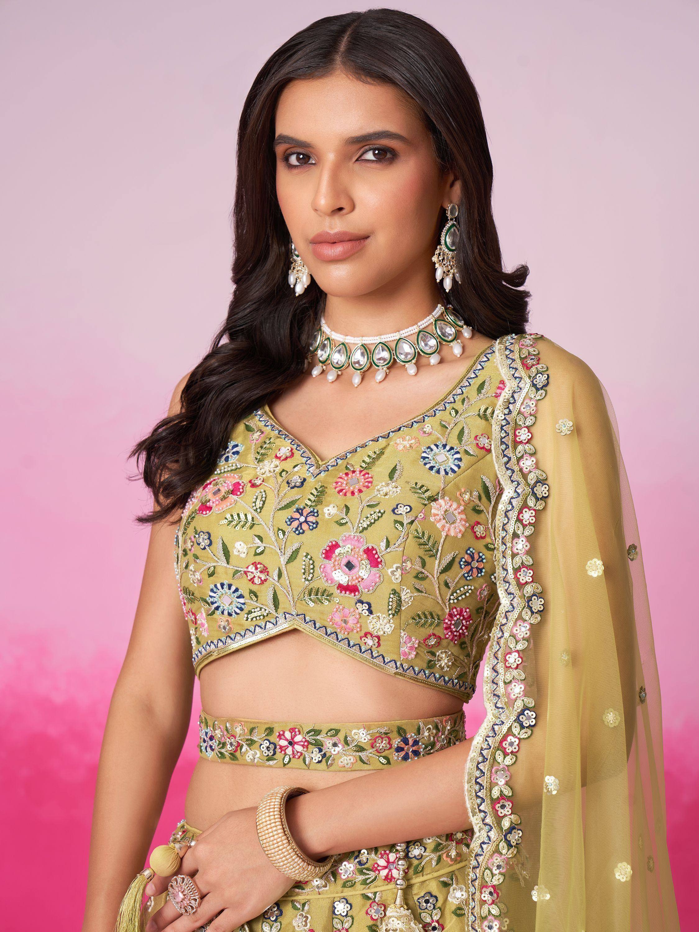 Woman in mustard yellow floral embroidered lehenga choli with matching dupatta and jewelry