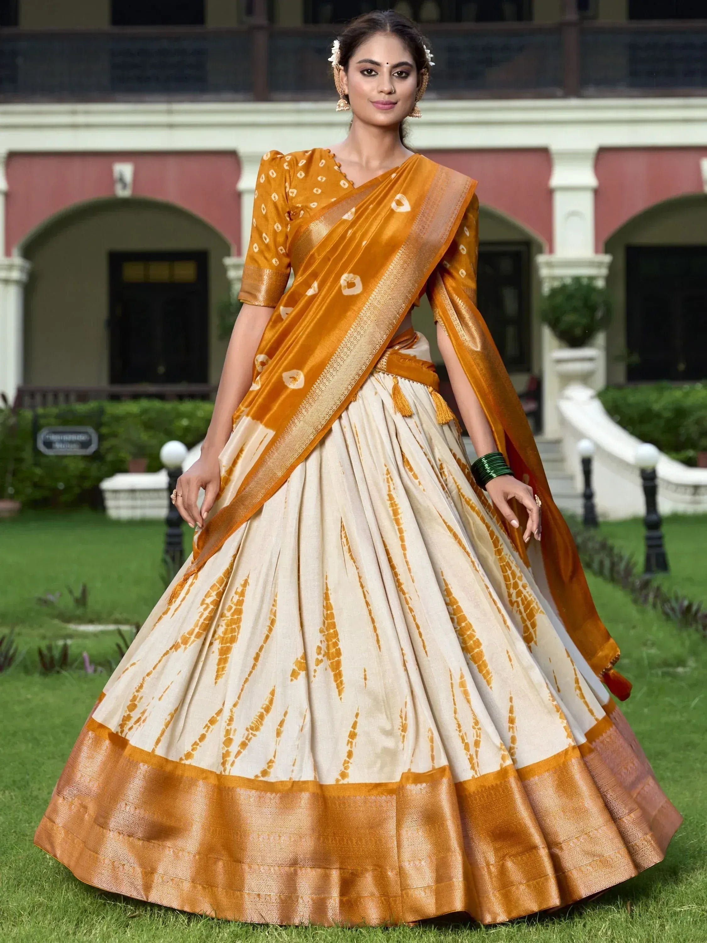 Woman in mustard and cream designer lehenga choli with printed dupatta, ethnic Indian wear