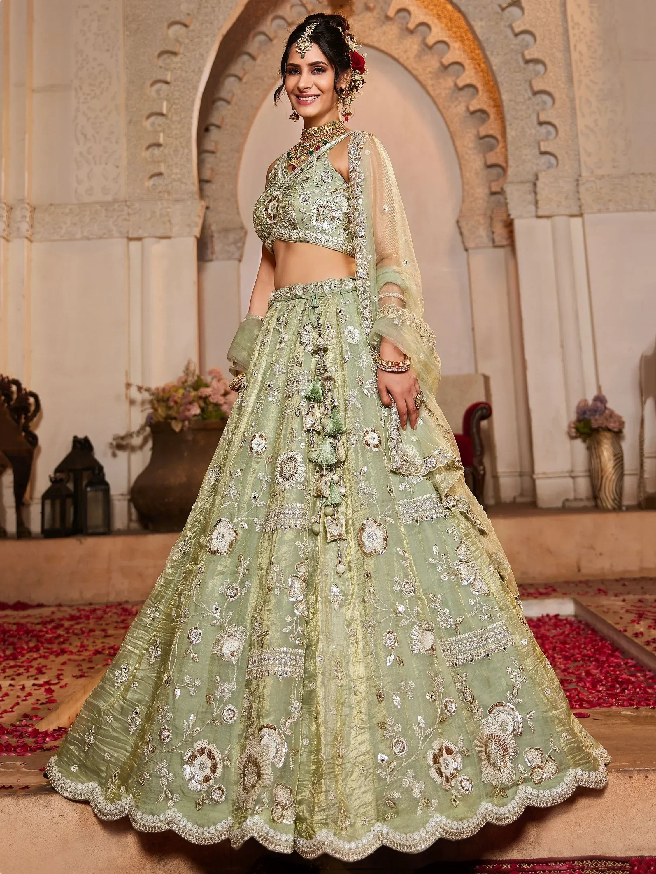 Mint green embroidered lehenga choli with floral motifs and tassels, perfect for Indian weddings and festive occasions.