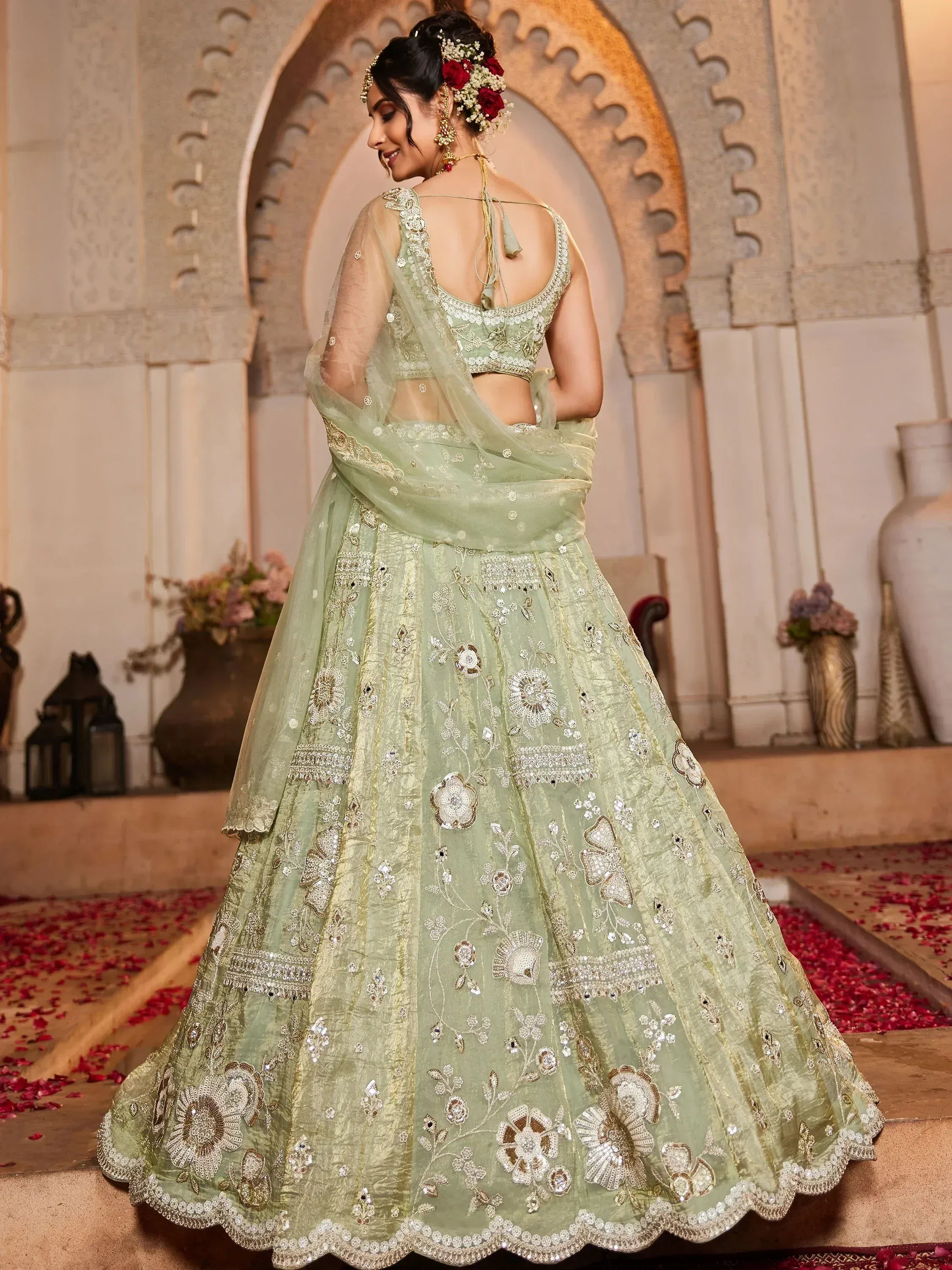 Mint green designer lehenga choli with floral embroidery and sheer dupatta, perfect for Indian weddings.