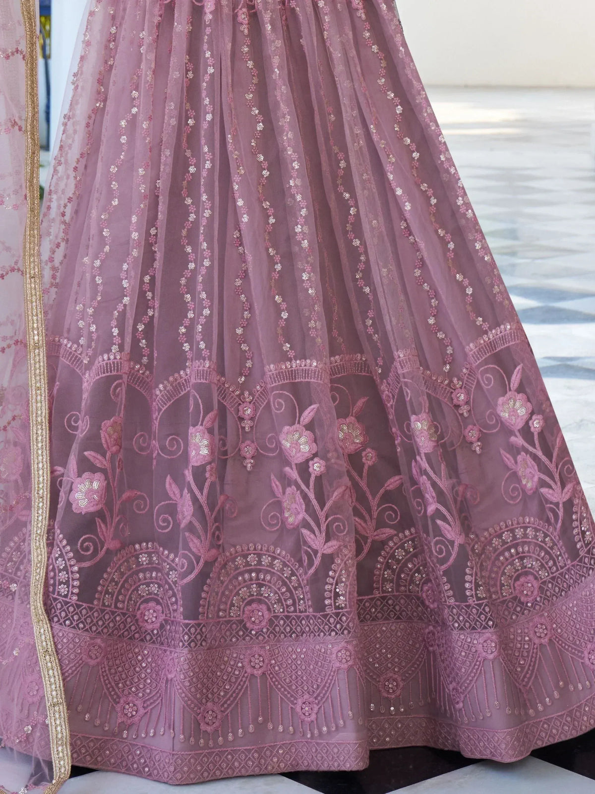 Dusty pink embroidered lehenga with floral motifs and gold detailing, ideal for Indian ethnic wear occasions.