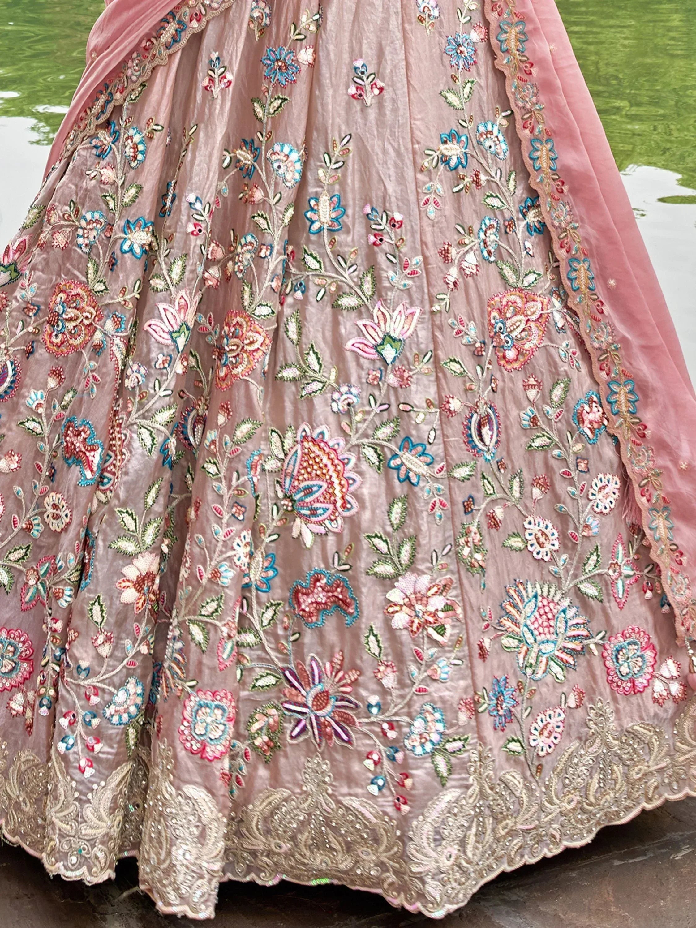 Pink embroidered lehenga with floral motifs and gold border, ideal for Indian weddings and festive occasions.