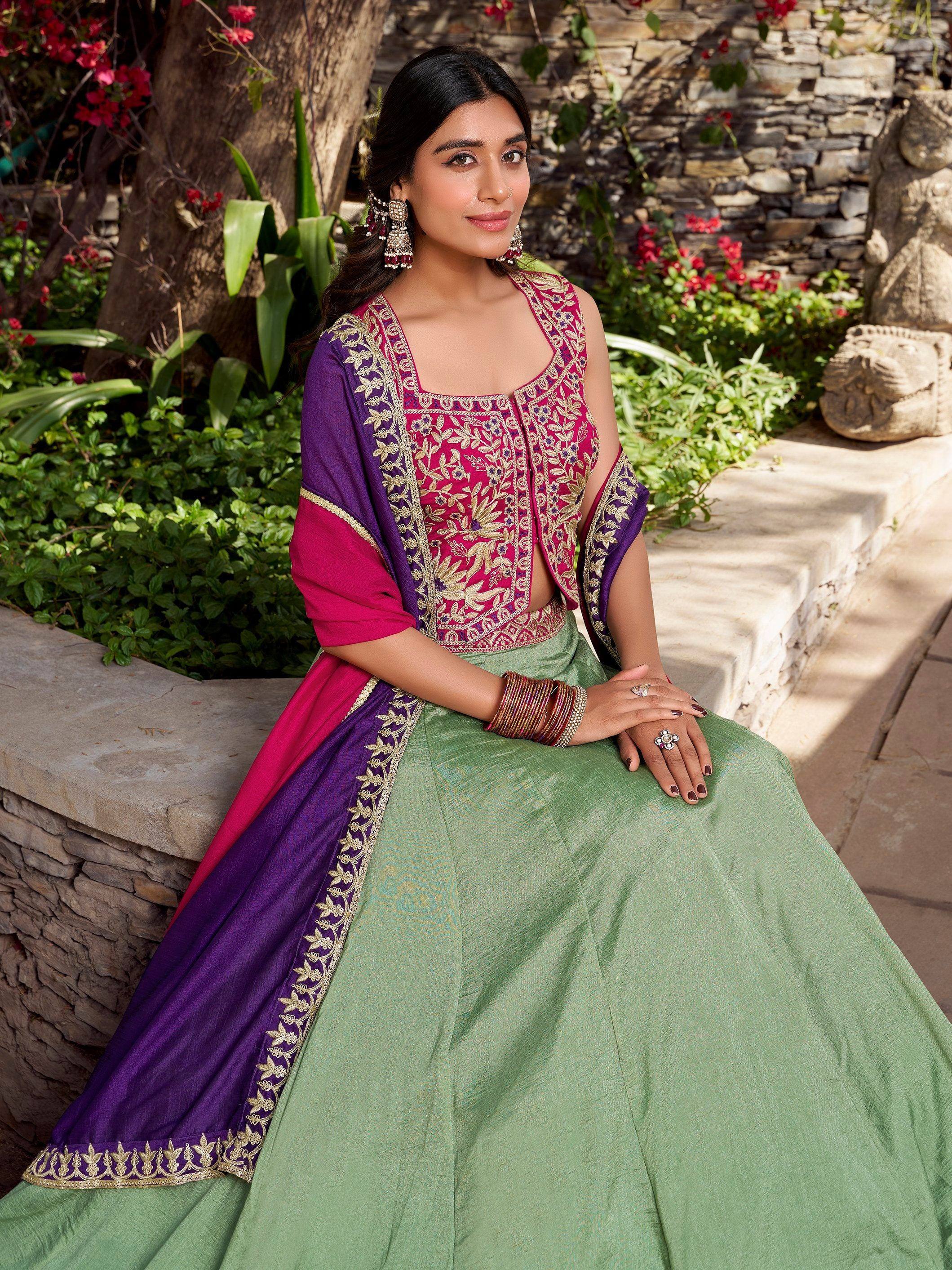 Woman in embroidered pink and purple lehenga choli with green skirt, perfect for Indian ethnic wear occasions