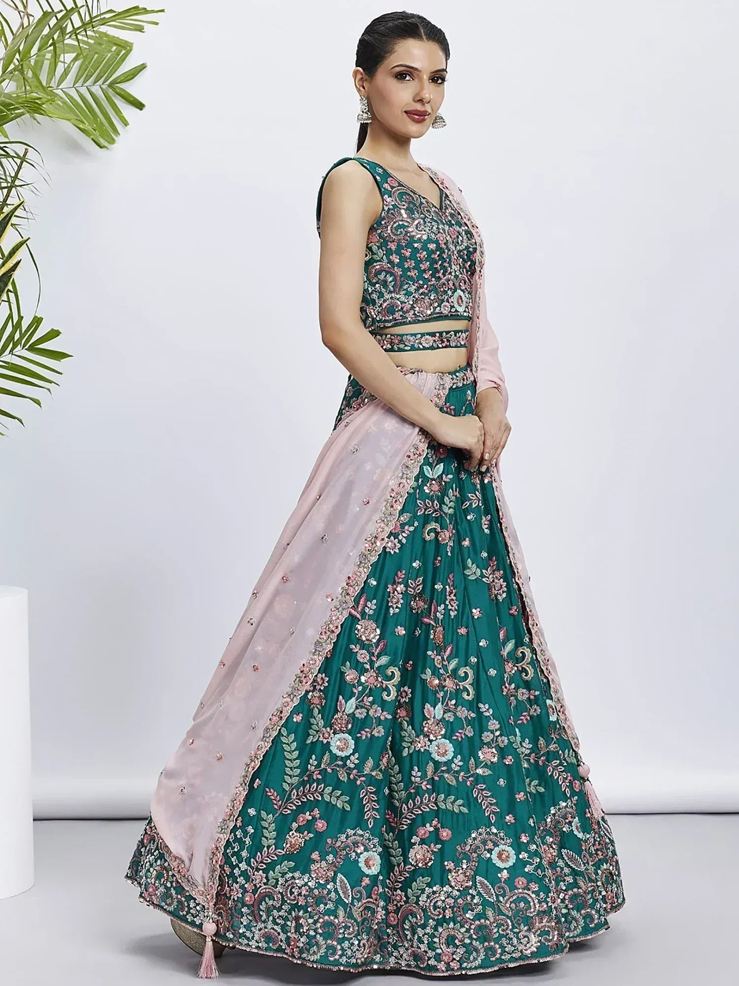 Emerald green floral embroidered lehenga choli with pink dupatta, perfect for Indian weddings and festive occasions.