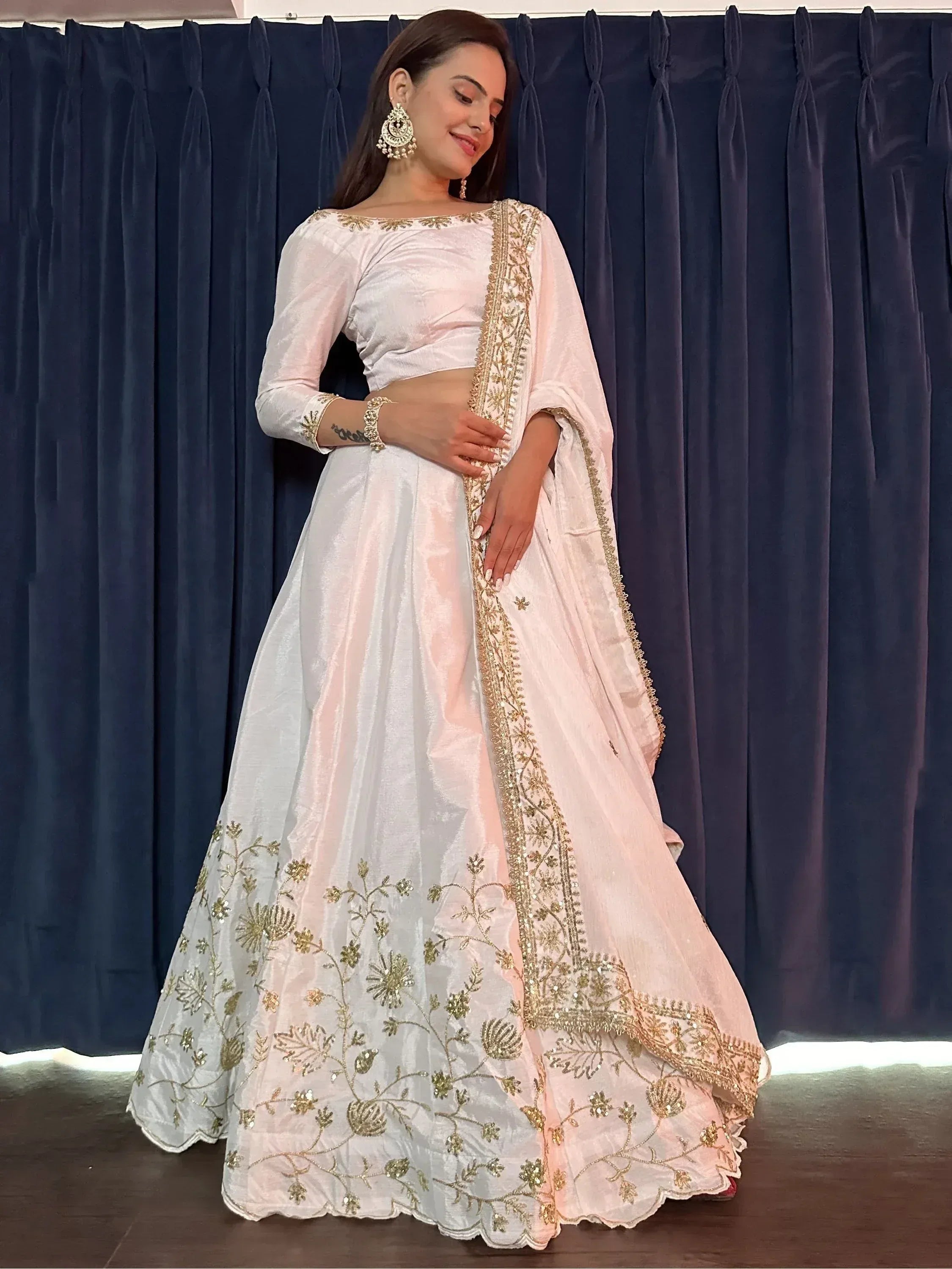 Elegant white lehenga choli with gold floral embroidery, perfect for Indian ethnic wear occasions.