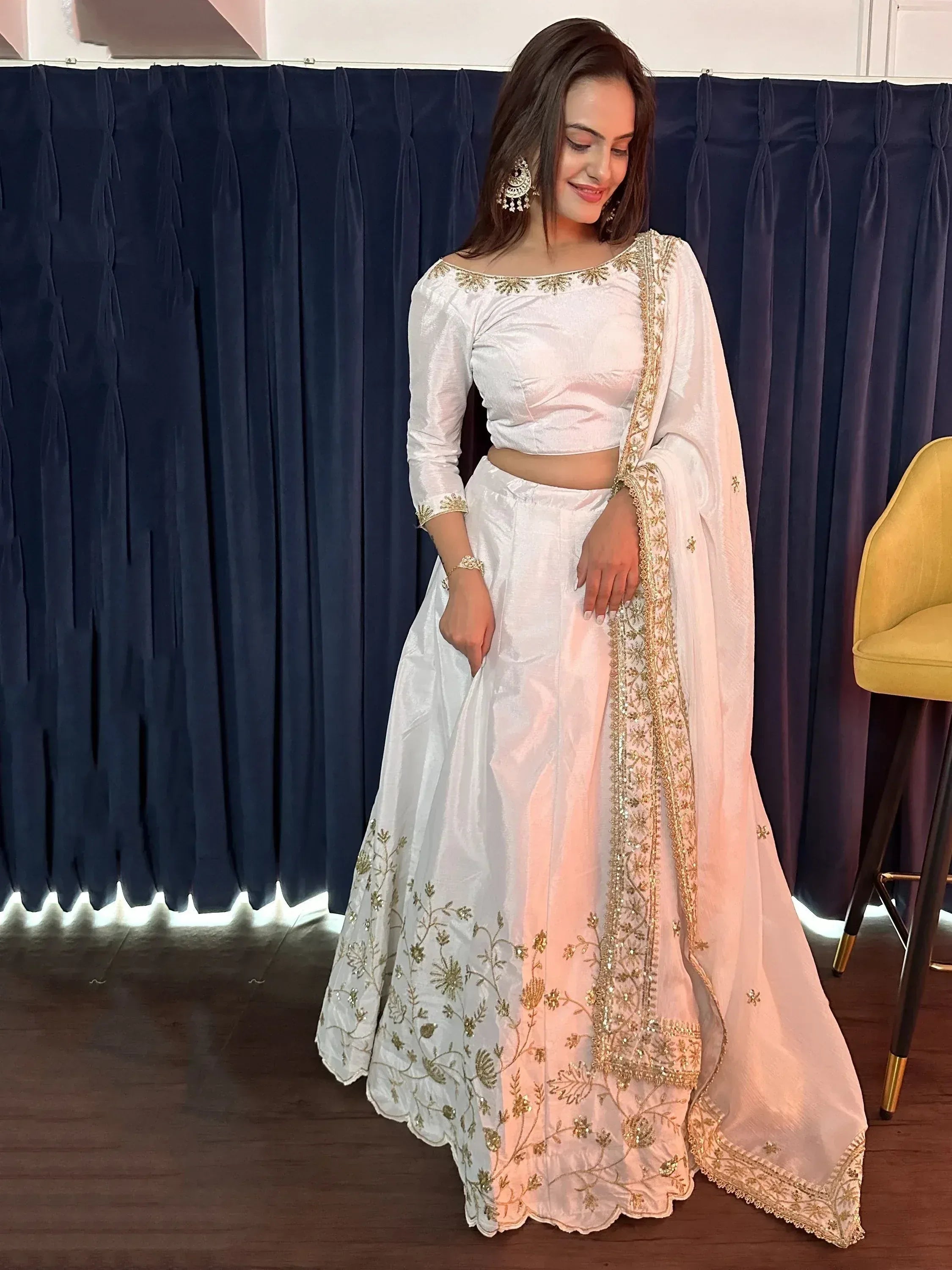 White embroidered lehenga choli with gold detailing, perfect for Indian ethnic wear and festive occasions.