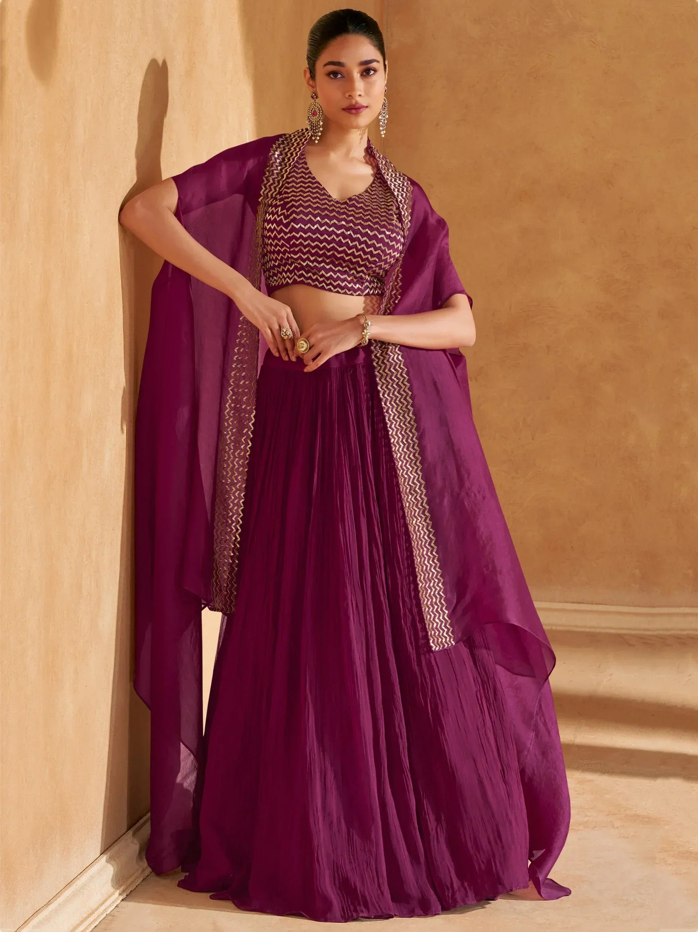 Purple ethnic lehenga choli with gold zigzag embroidery, pleated skirt, and sheer dupatta for Indian occasions