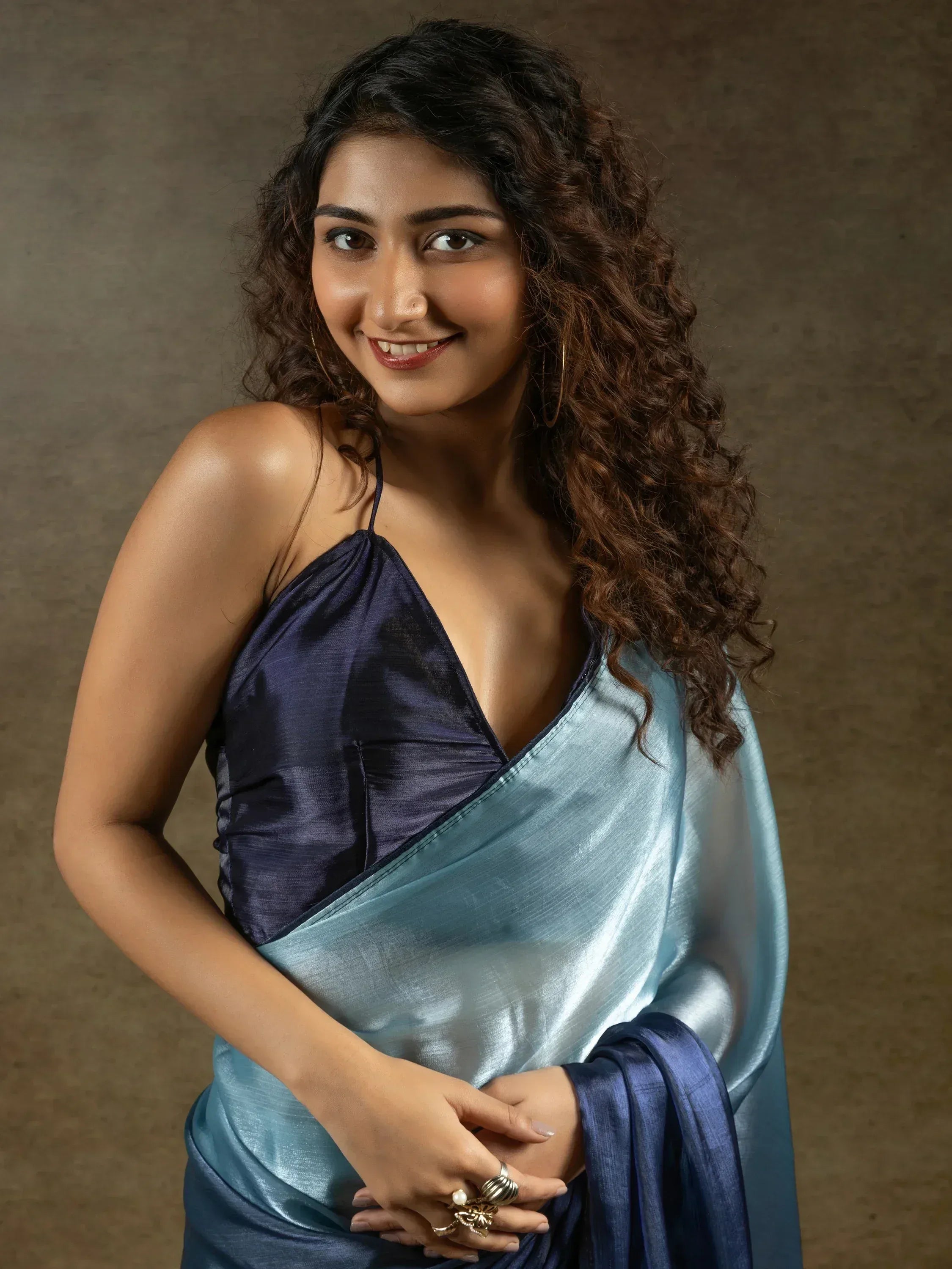 Woman in elegant blue satin saree with matching blouse, showcasing Indian ethnic wear style