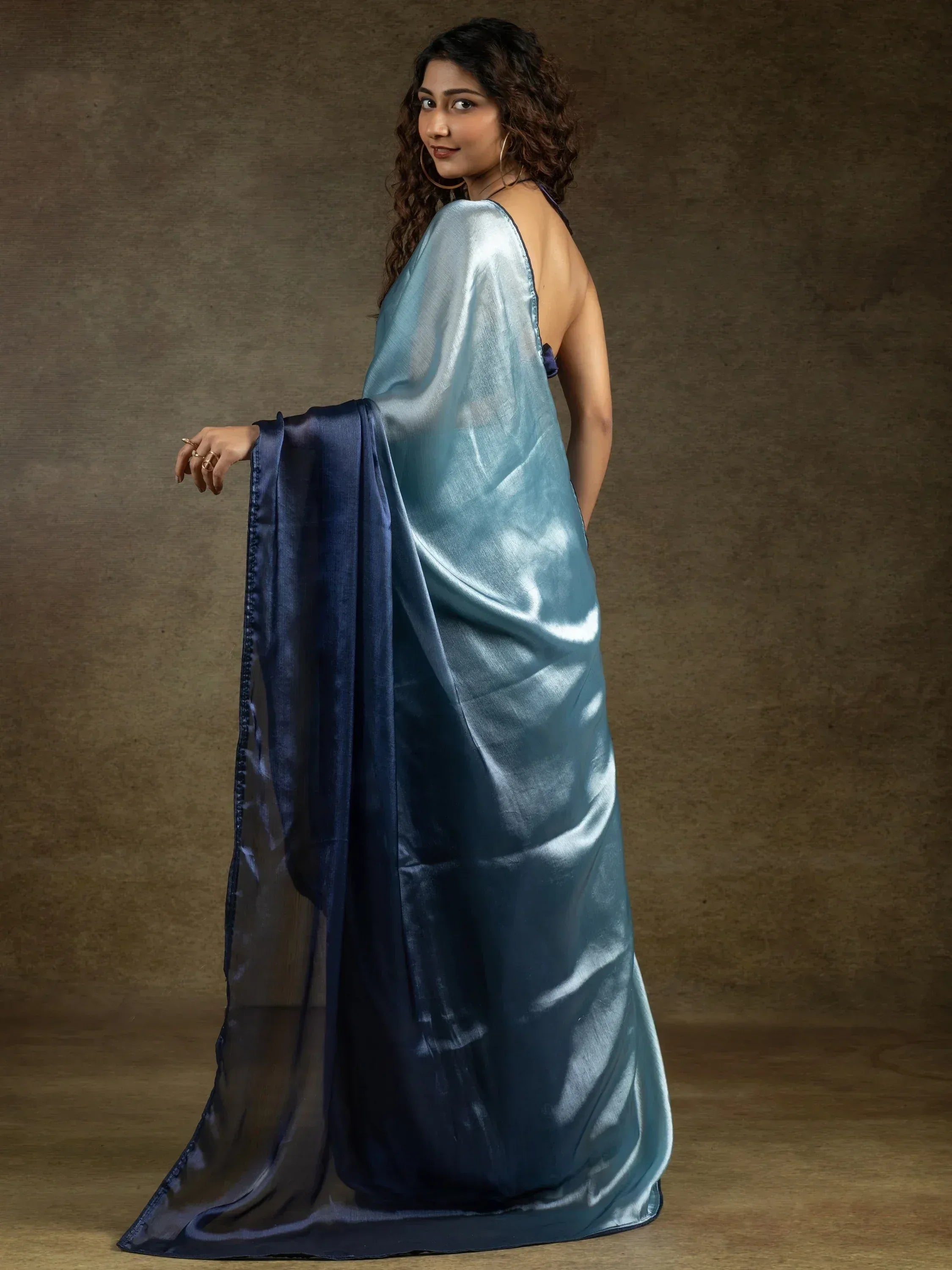 Woman in elegant blue satin saree with ombre effect, perfect for Indian ethnic wear occasions.
