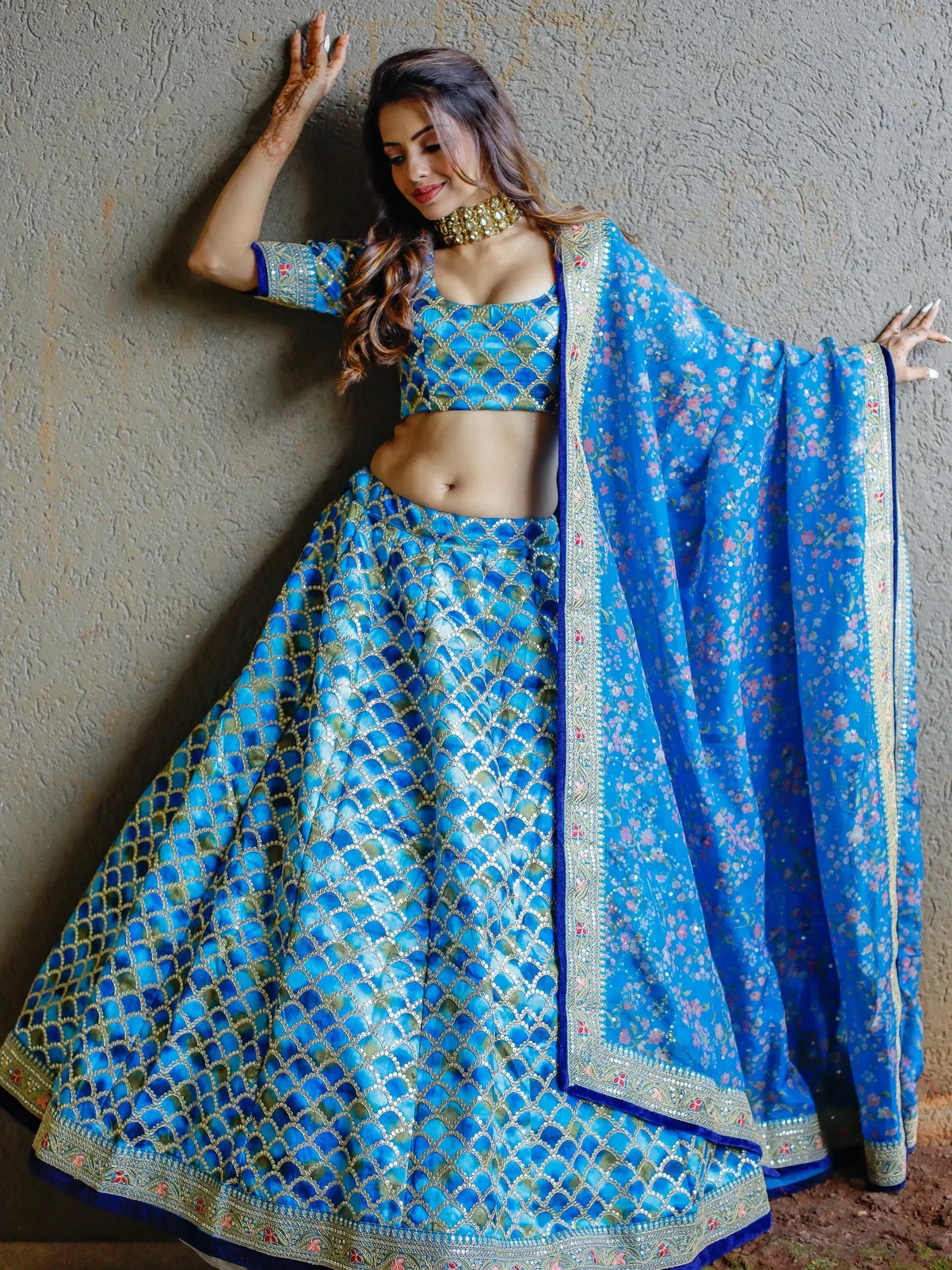 Blue designer lehenga choli with gold embroidery and floral dupatta, perfect for Indian ethnic wear events.