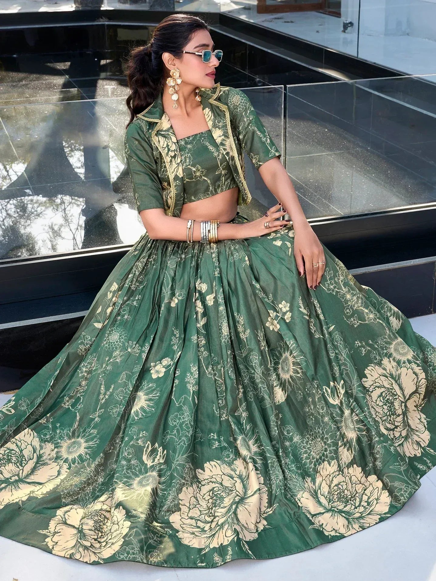 Green floral lehenga choli with gold embroidery, styled with sunglasses and statement earrings.