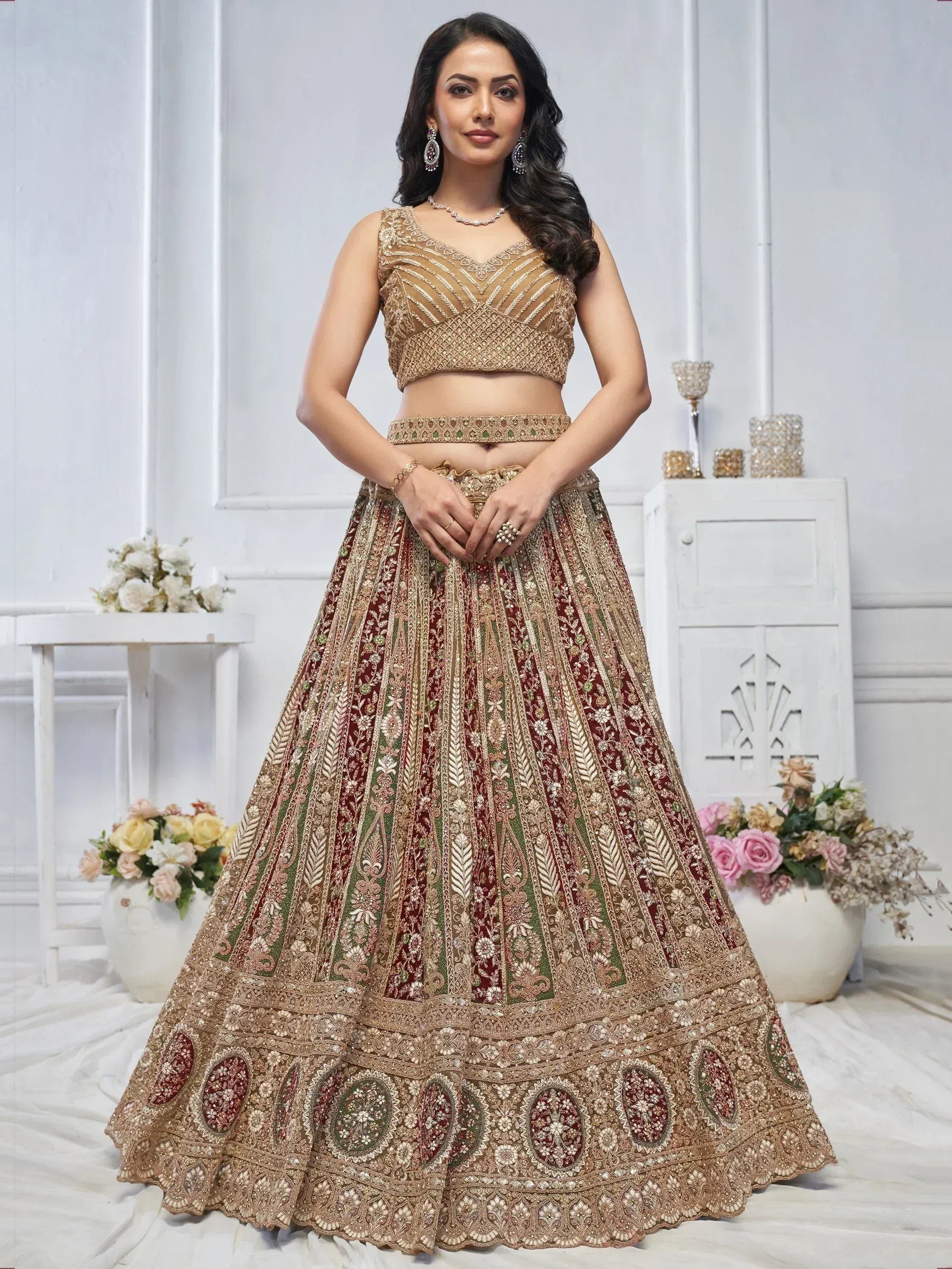 Elegant maroon and gold embroidered lehenga choli for Indian weddings, featuring intricate floral patterns and heavy embellishments.