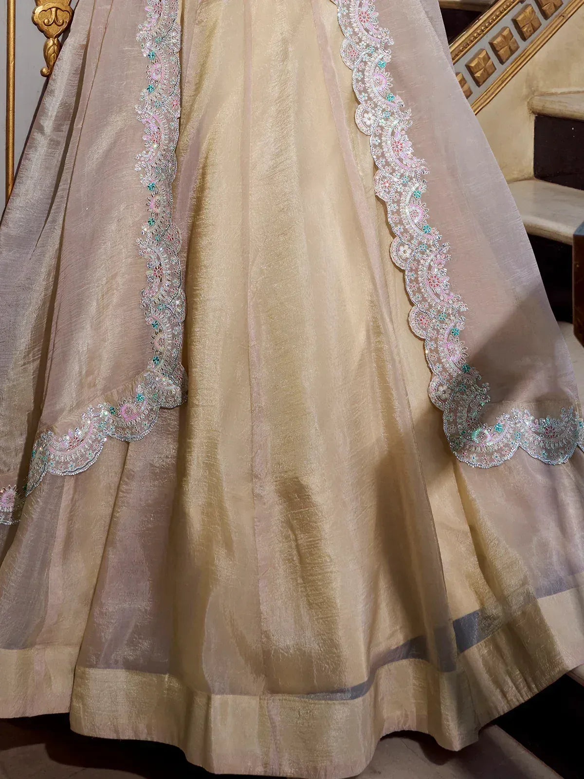 Beige lehenga with intricate floral embroidery and scalloped lace detailing, perfect for Indian ethnic wear.