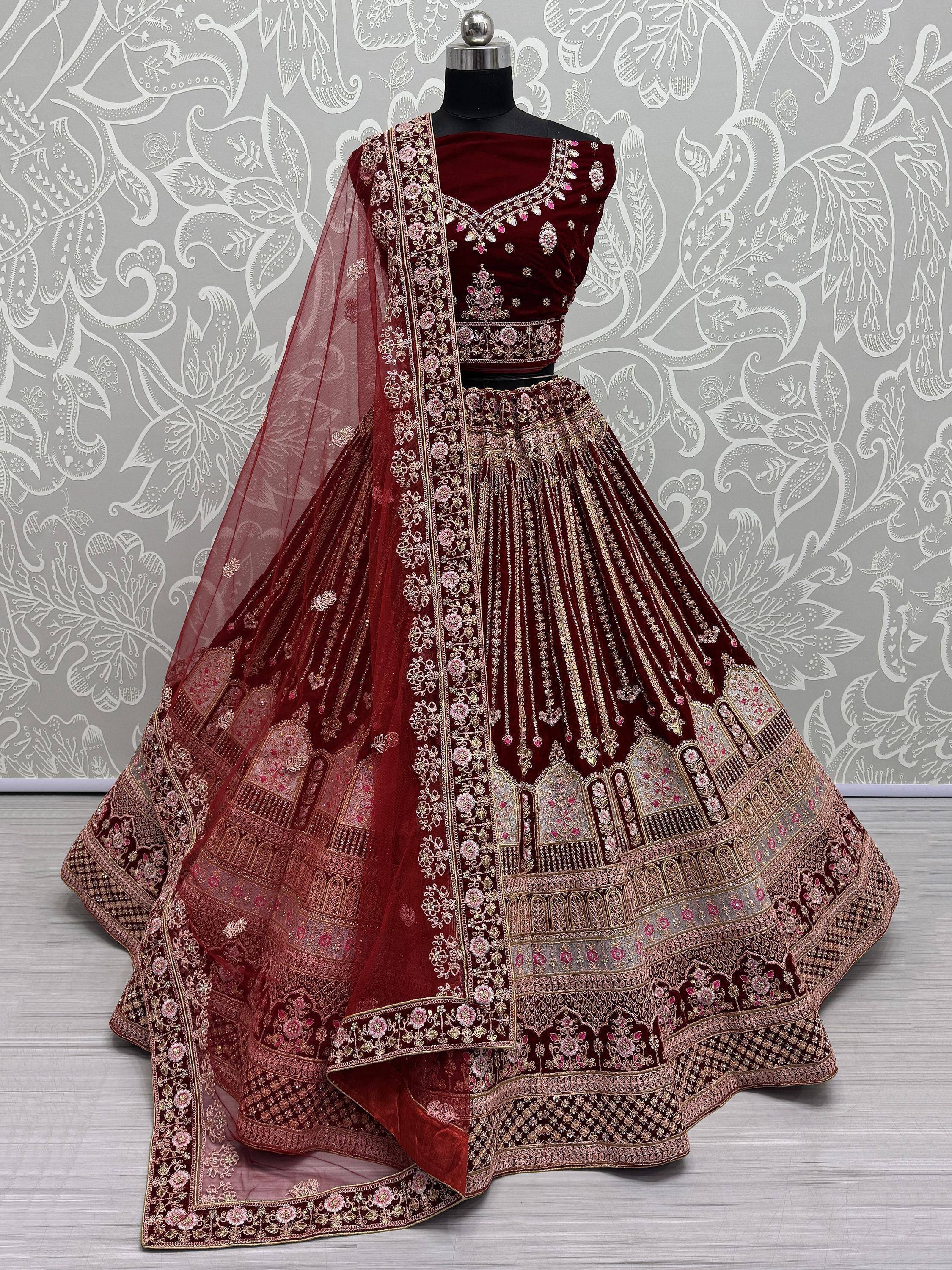 Maroon velvet designer lehenga choli with heavy gold embroidery and floral motifs, perfect for weddings
