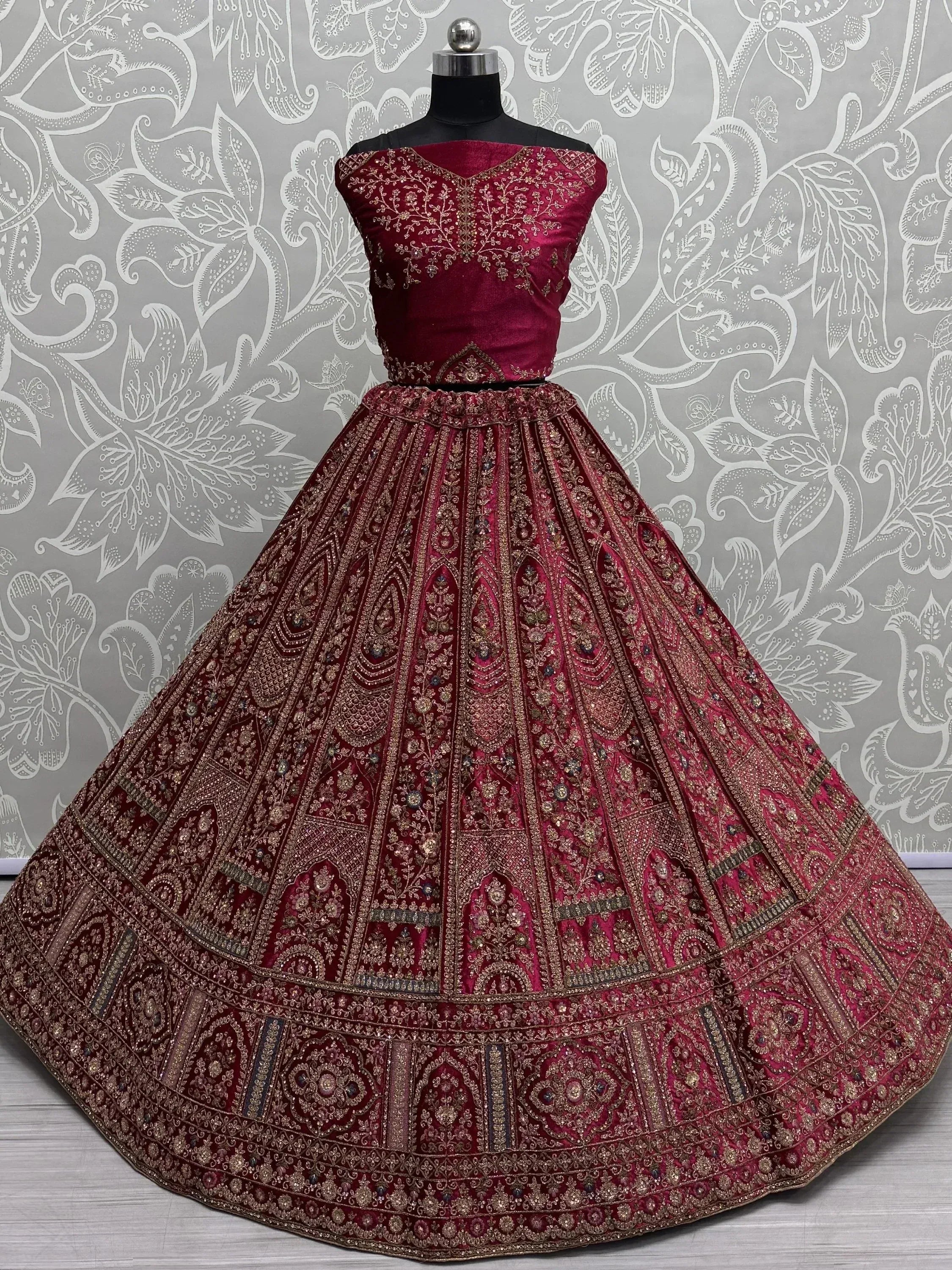 Maroon velvet lehenga choli with heavy gold embroidery, perfect for Indian weddings and festive occasions.