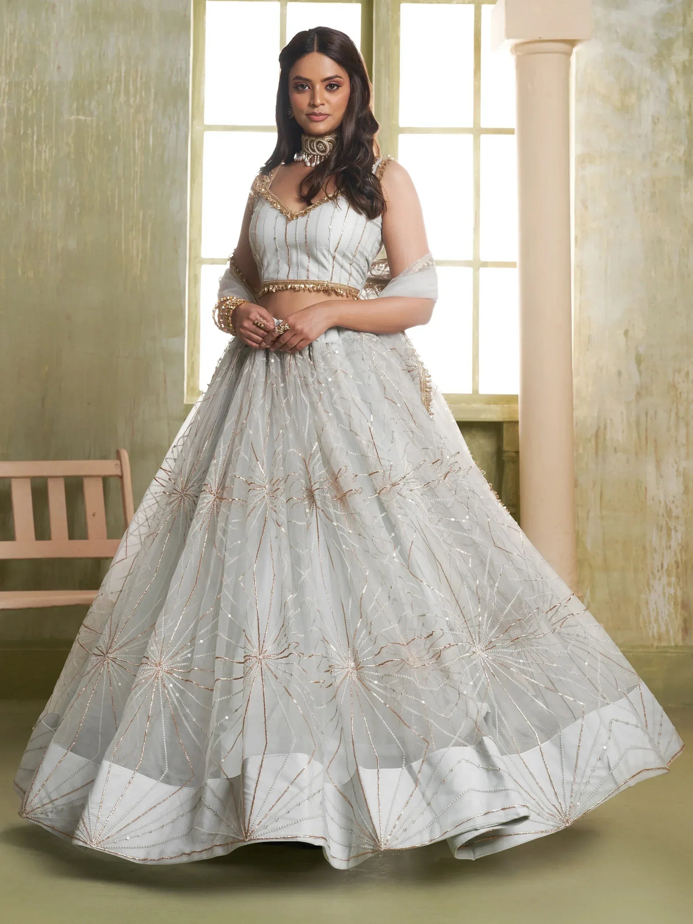 Elegant light blue lehenga choli with gold embroidery, perfect for Indian weddings and festive occasions.