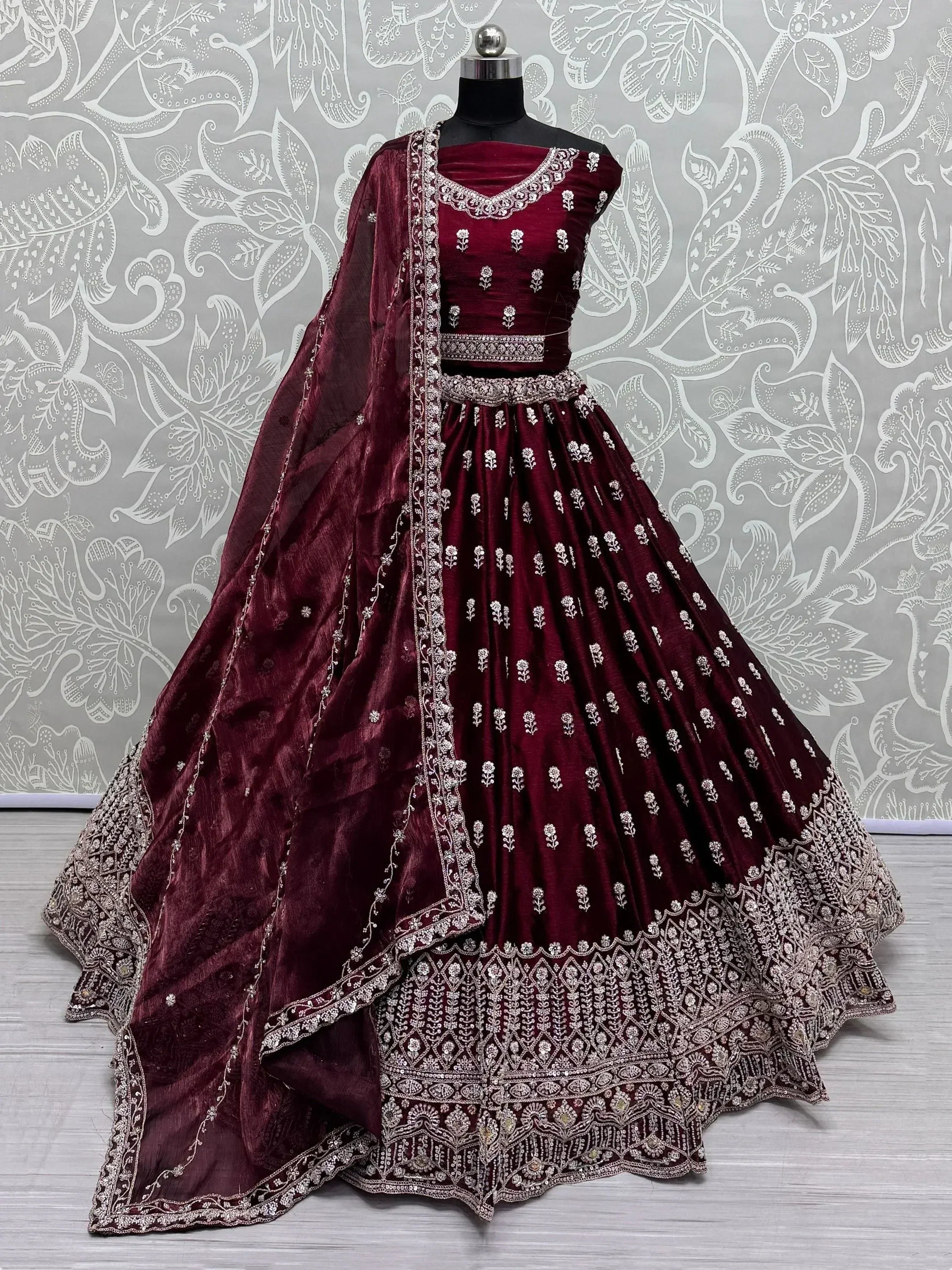 Burgundy velvet lehenga choli with silver embroidery, perfect for Indian weddings and festive occasions.
