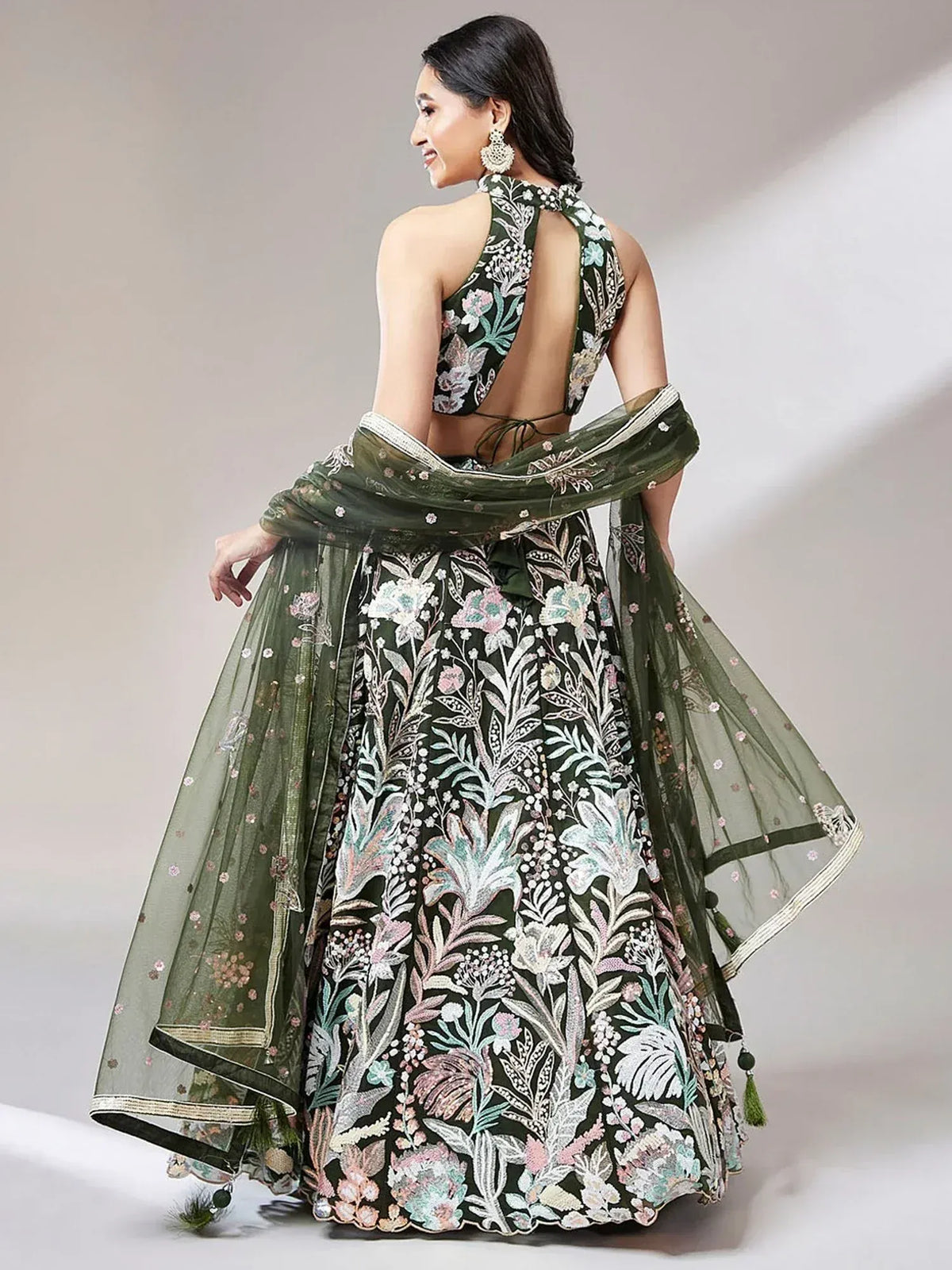 Green floral embroidered lehenga choli with backless blouse and sheer dupatta, perfect for Indian ethnic occasions