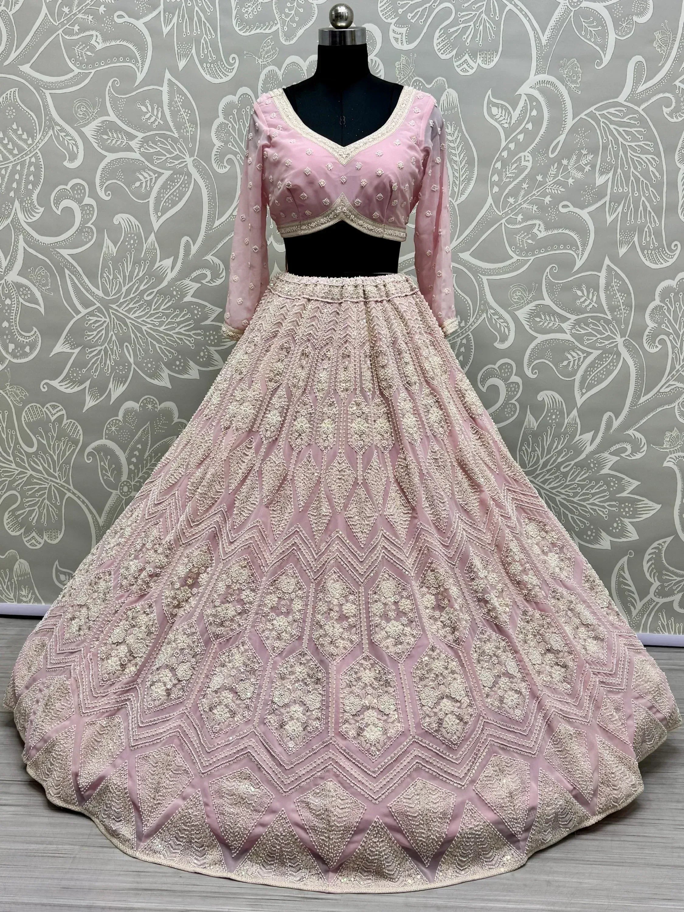 Pink designer lehenga choli with heavy embroidery and geometric patterns, perfect for weddings and festive occasions.