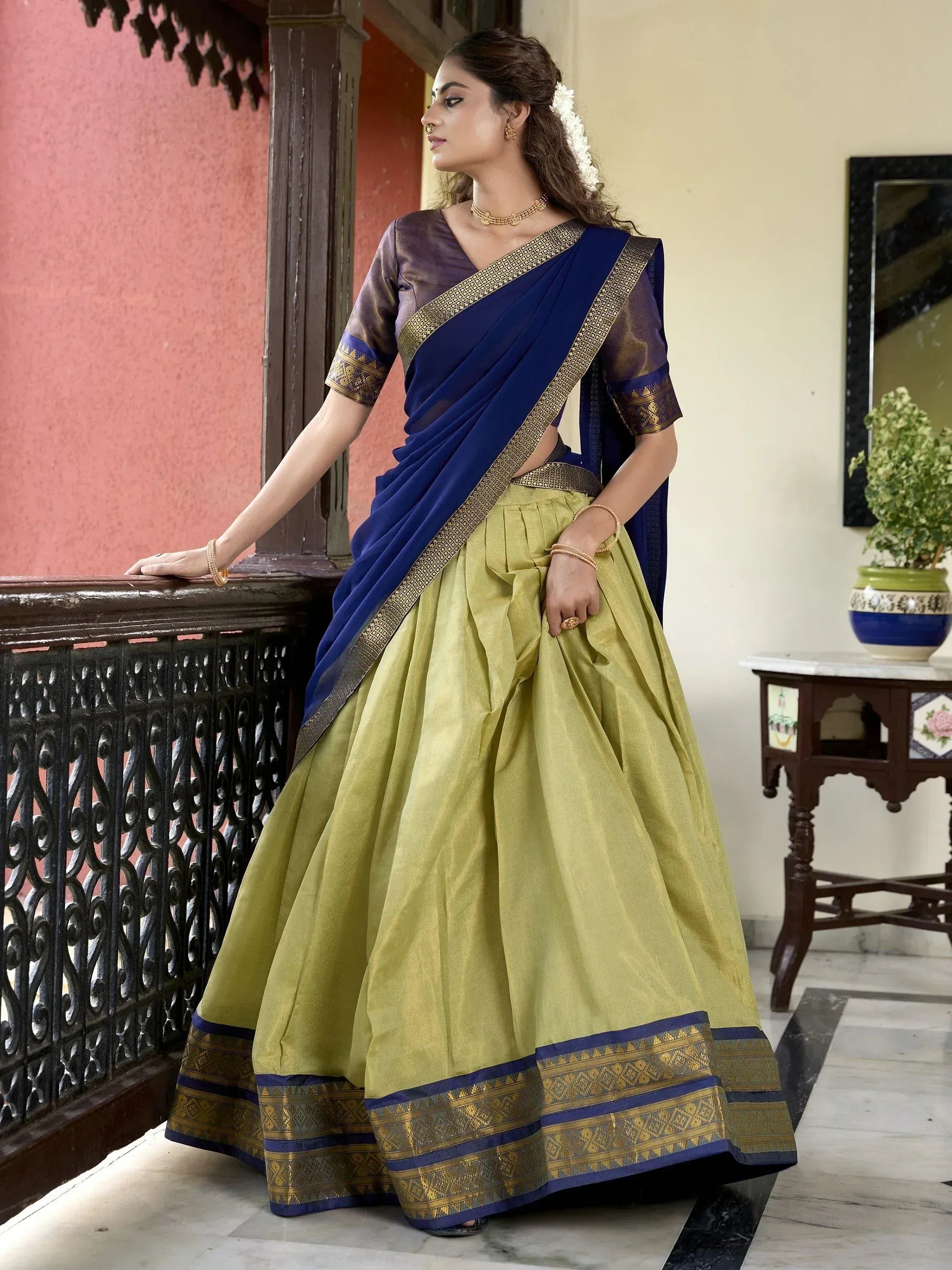 Elegant Indian lehenga choli with blue saree drape, gold border, and olive green skirt for festive occasions