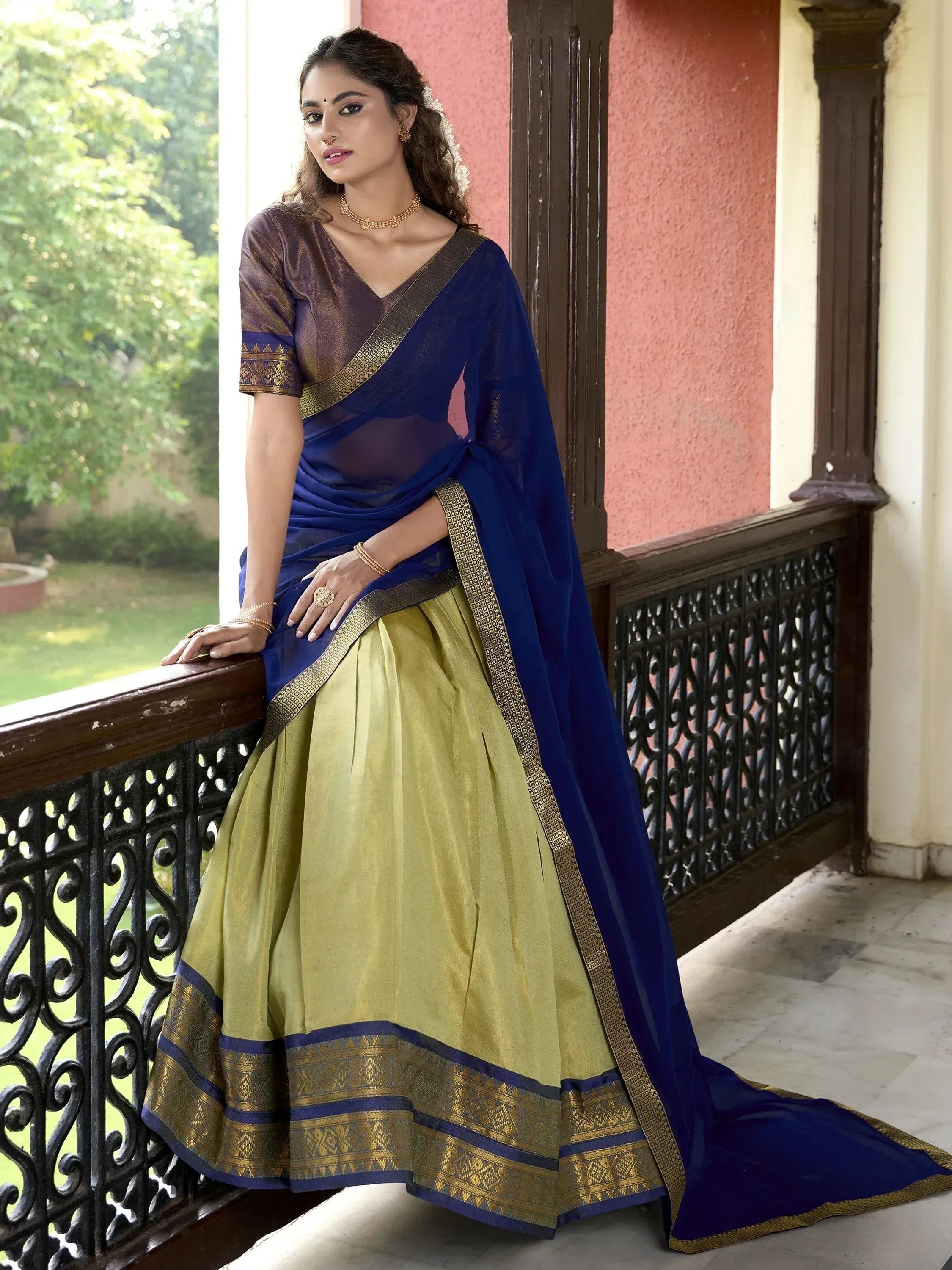 Woman in blue and olive green designer lehenga choli with gold border, perfect for Indian ethnic wear occasions