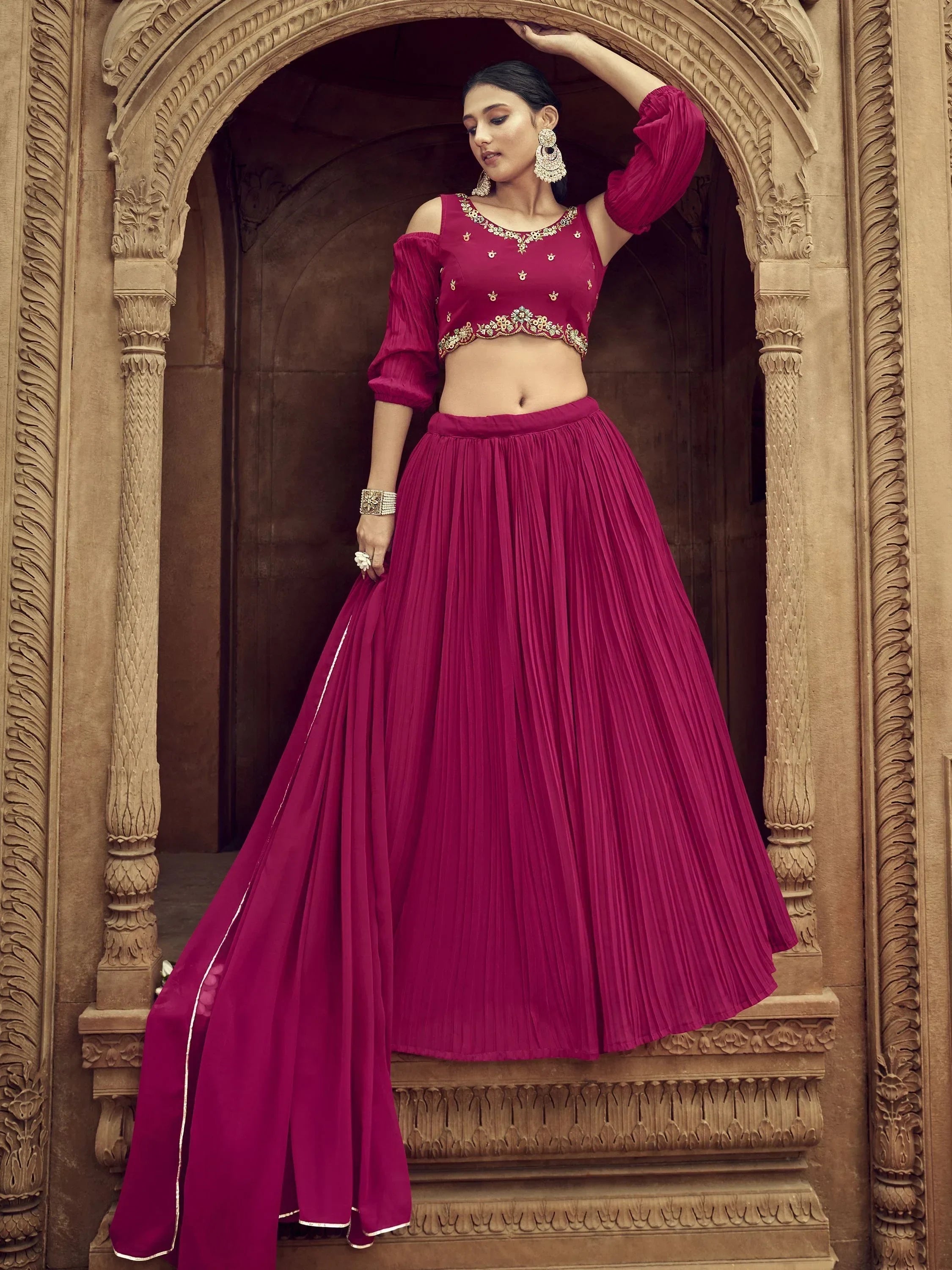 Magenta designer lehenga choli with gold embroidery, pleated skirt, and off-shoulder top for Indian ethnic wear
