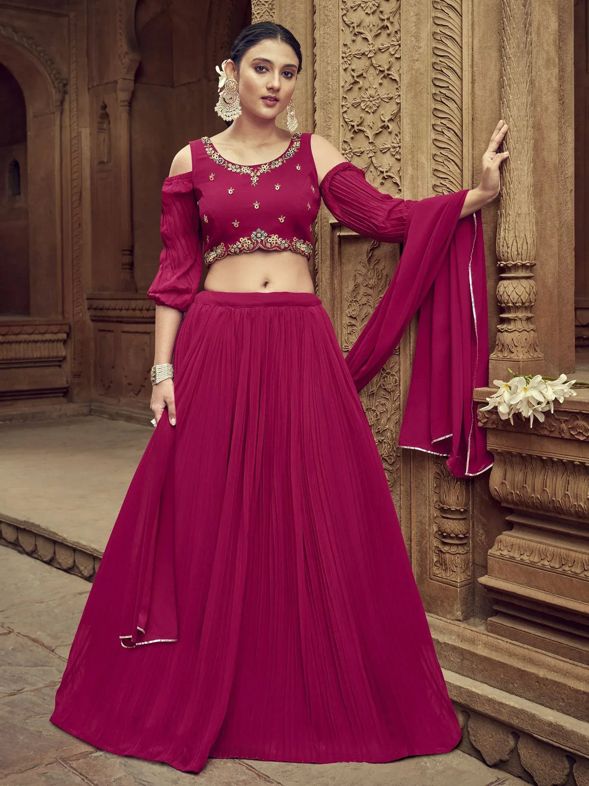 Burgundy ethnic lehenga choli with cold shoulder blouse, pleated skirt, and dupatta, perfect for Indian weddings and festivals.