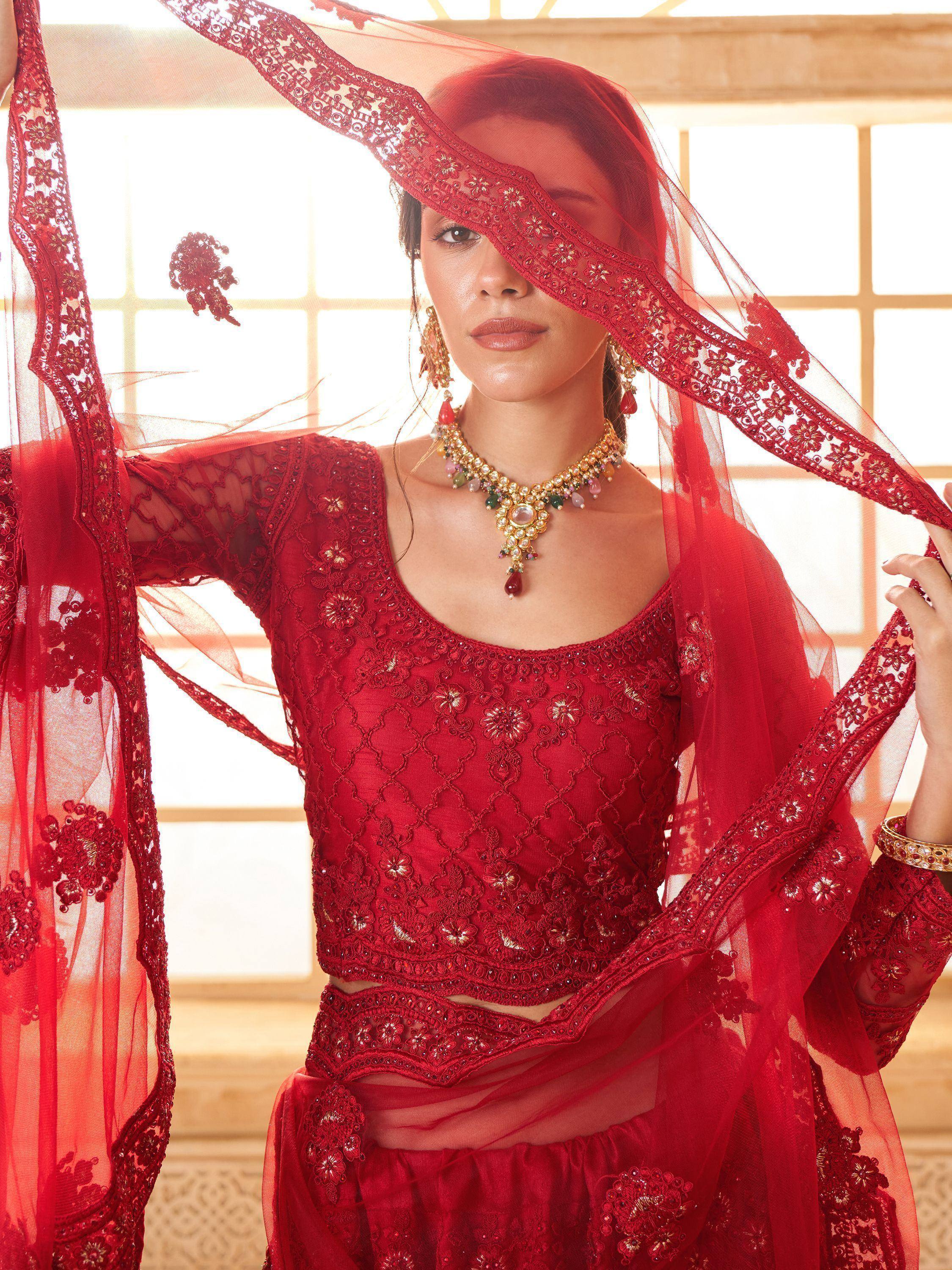 Red embroidered lehenga choli with sheer dupatta, perfect for Indian weddings and festive occasions.