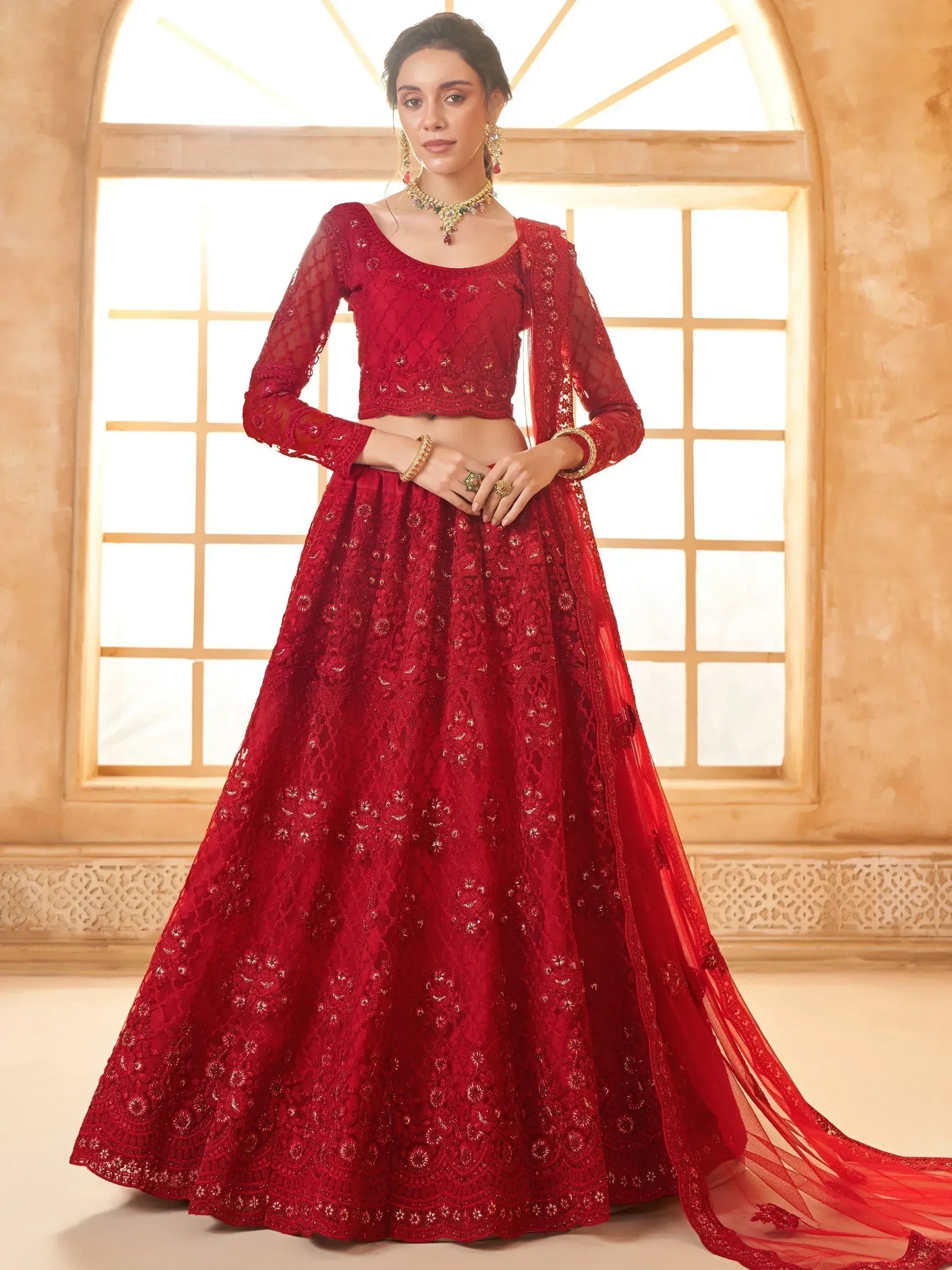 Red embroidered lehenga choli with sheer sleeves and dupatta, perfect for Indian weddings and festive occasions.