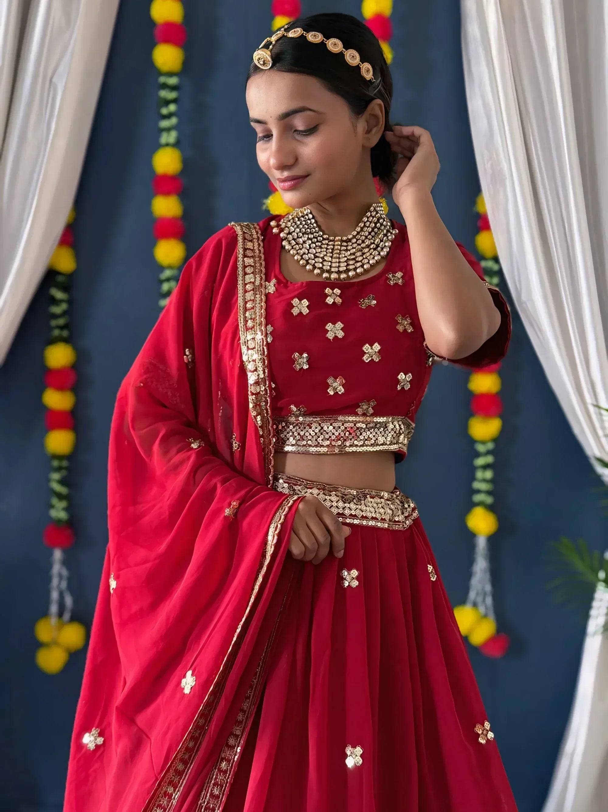 Red designer lehenga choli with gold embroidery, perfect for Indian weddings and festive occasions.