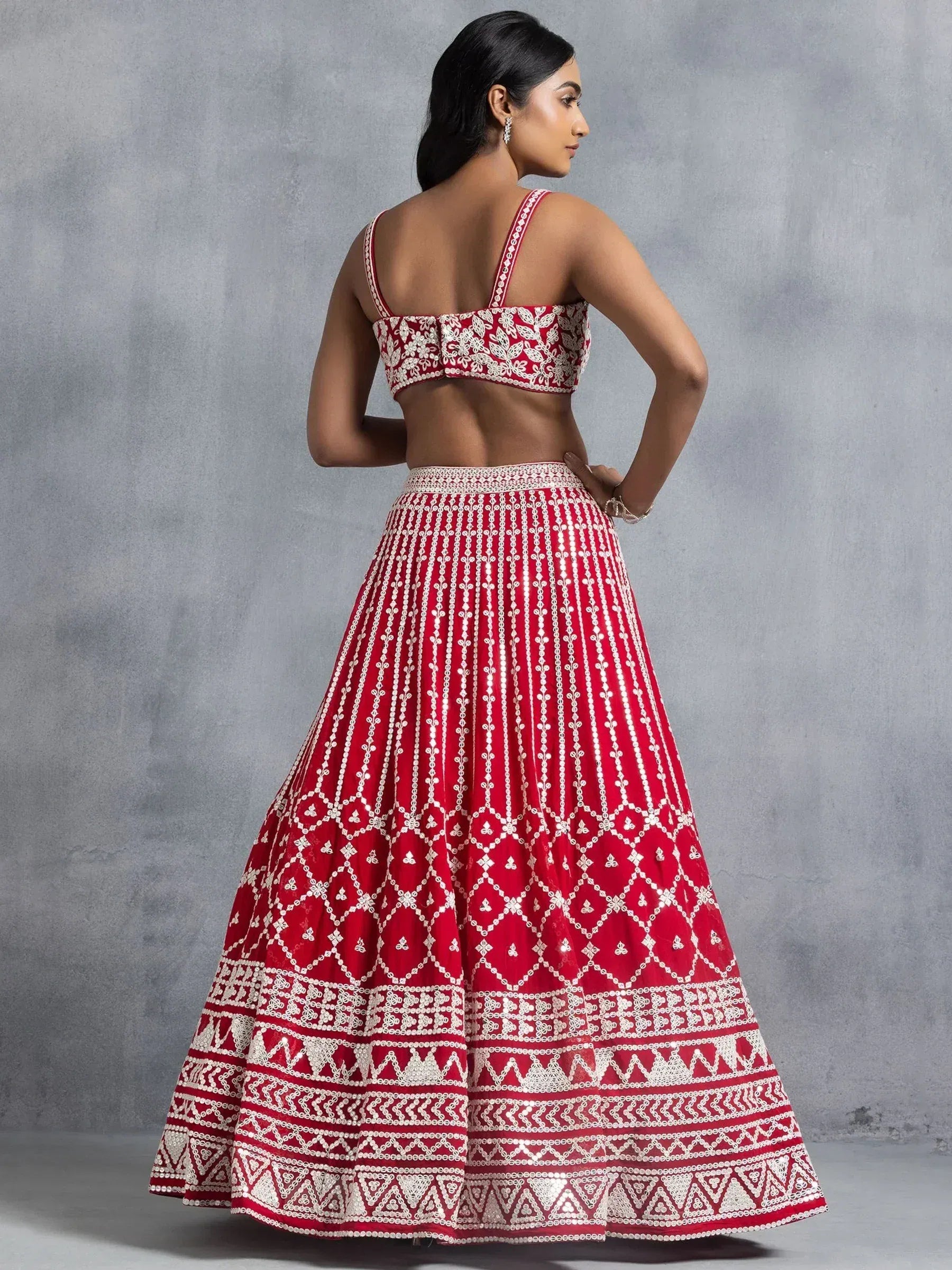 Red and white embroidered lehenga choli with intricate patterns, perfect for Indian ethnic wear occasions.
