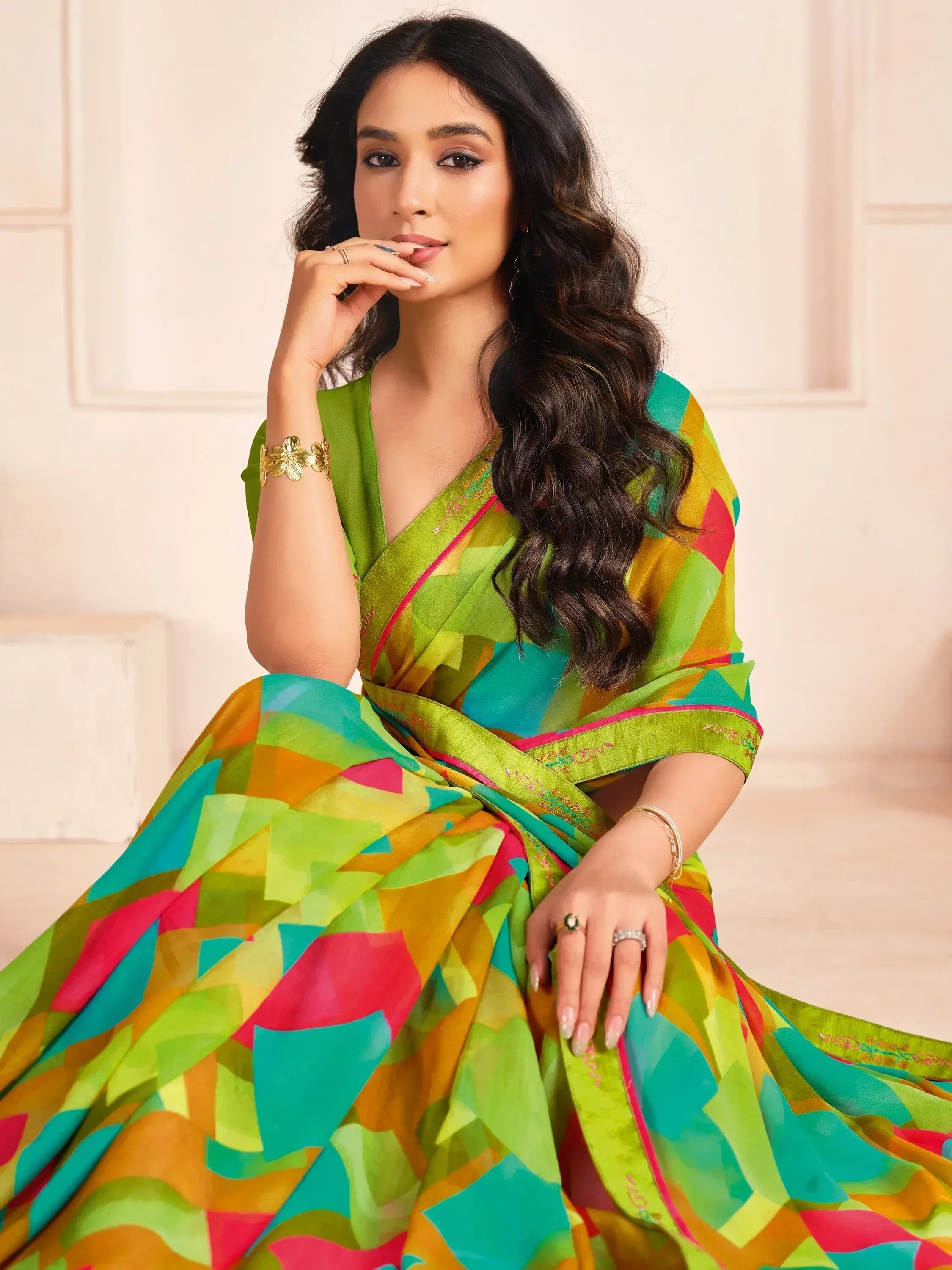 Woman in vibrant geometric print saree with green blouse, ethnic Indian wear