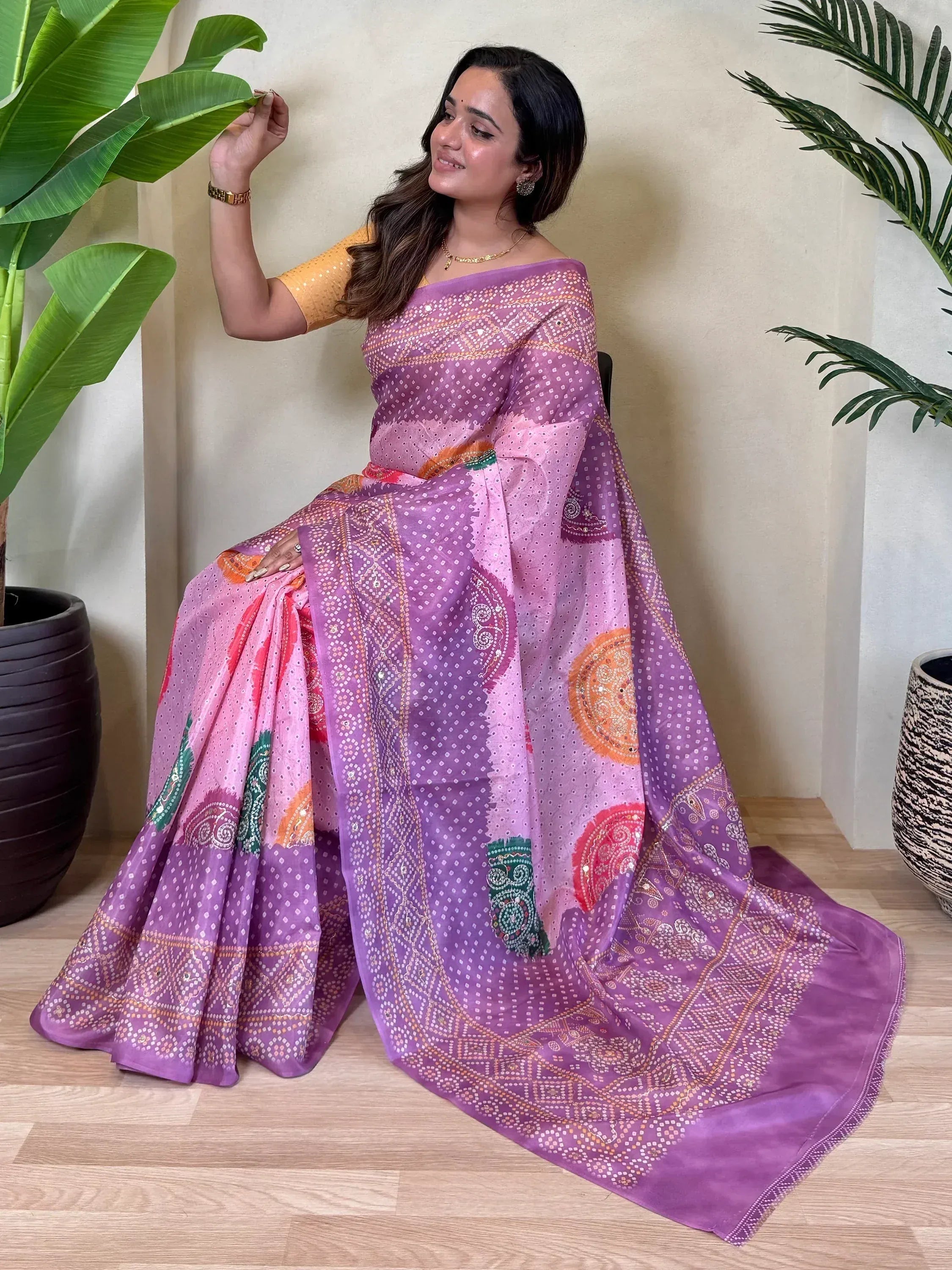 Woman in purple printed saree with yellow blouse, ethnic Indian wear, floral backdrop
