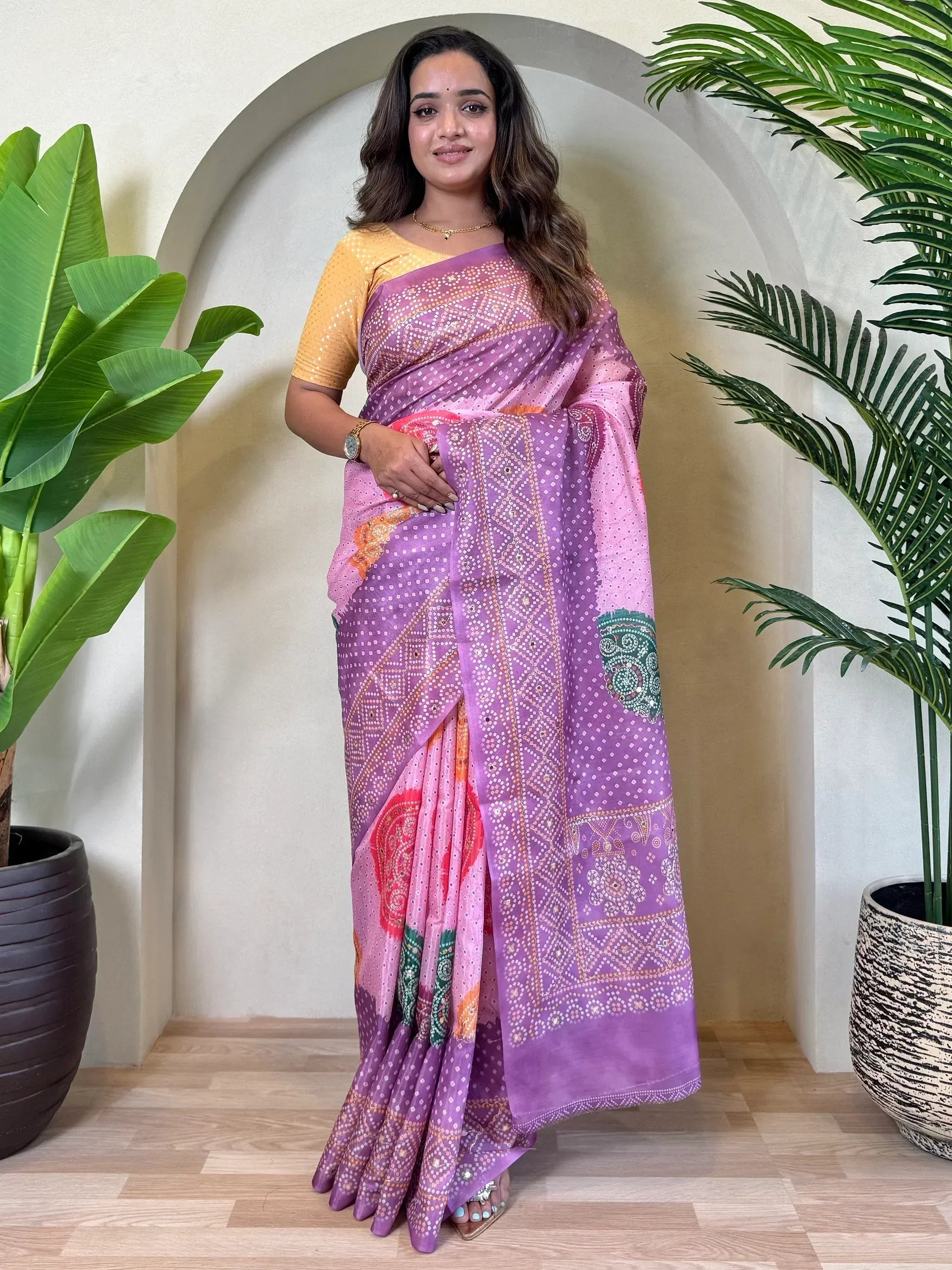 Woman wearing purple and pink printed saree with yellow blouse, ethnic Indian wear
