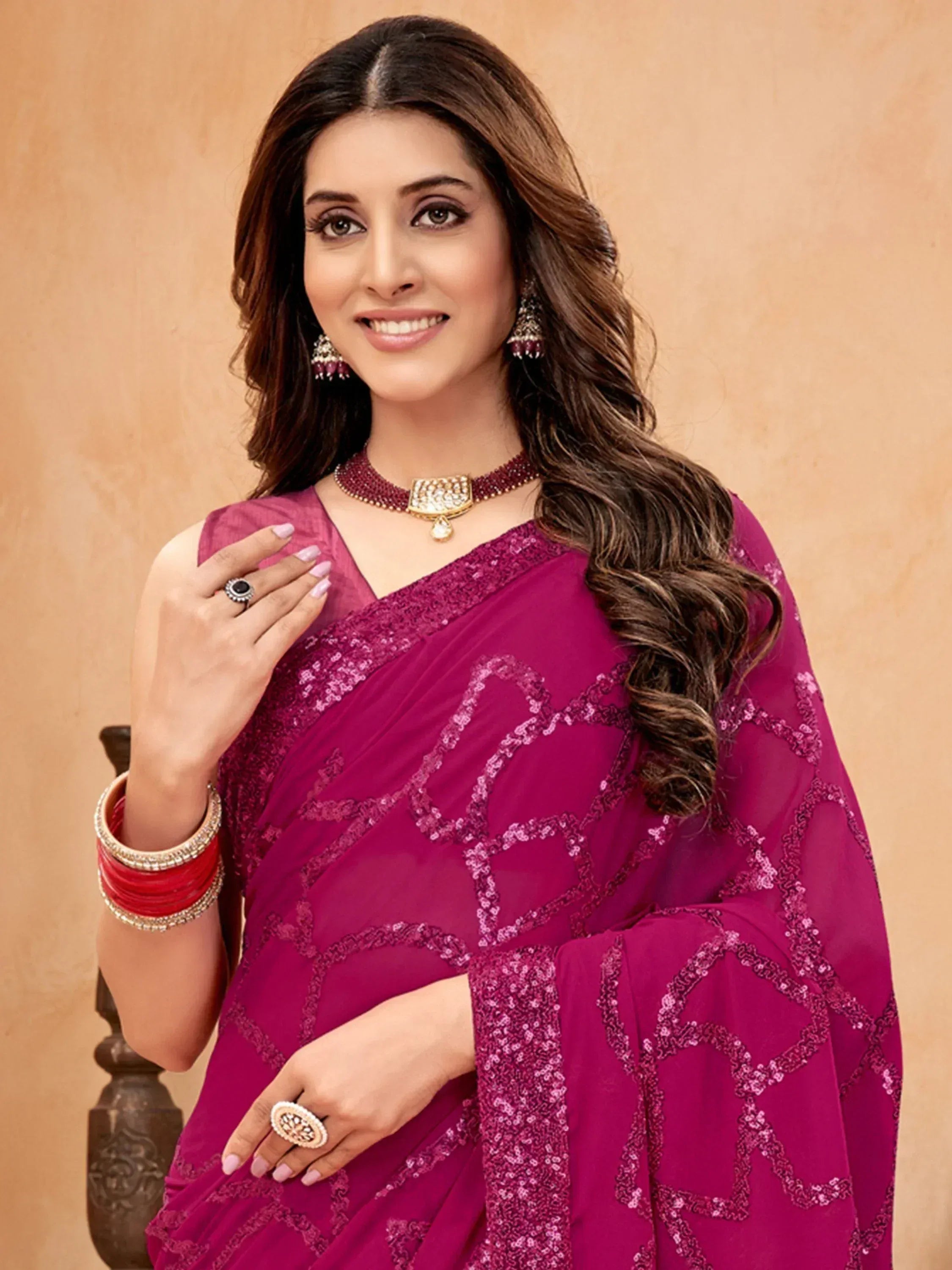 Elegant woman in magenta sequin saree with traditional jewelry, perfect for Indian ethnic wear occasions