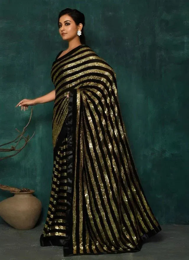 Black and gold striped sequin saree with elegant drape, perfect for festive occasions