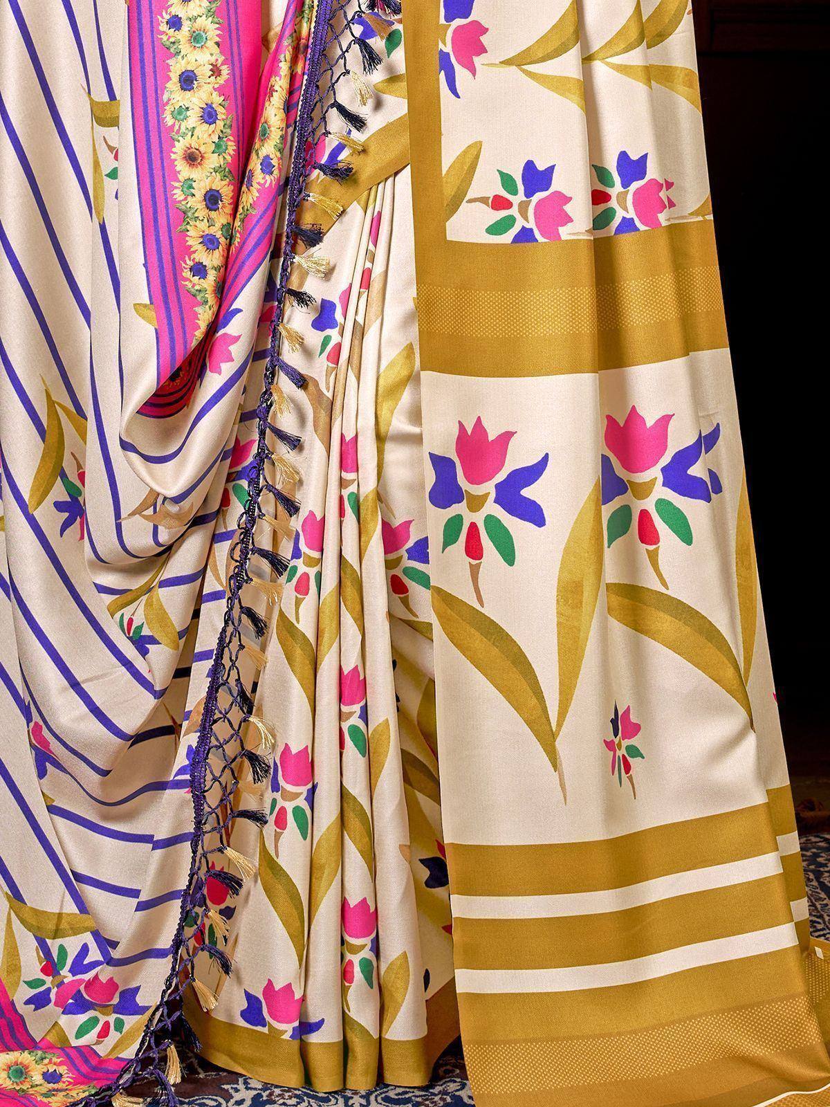 Cream saree with floral print, gold border, and purple tassels, ideal for ethnic occasions