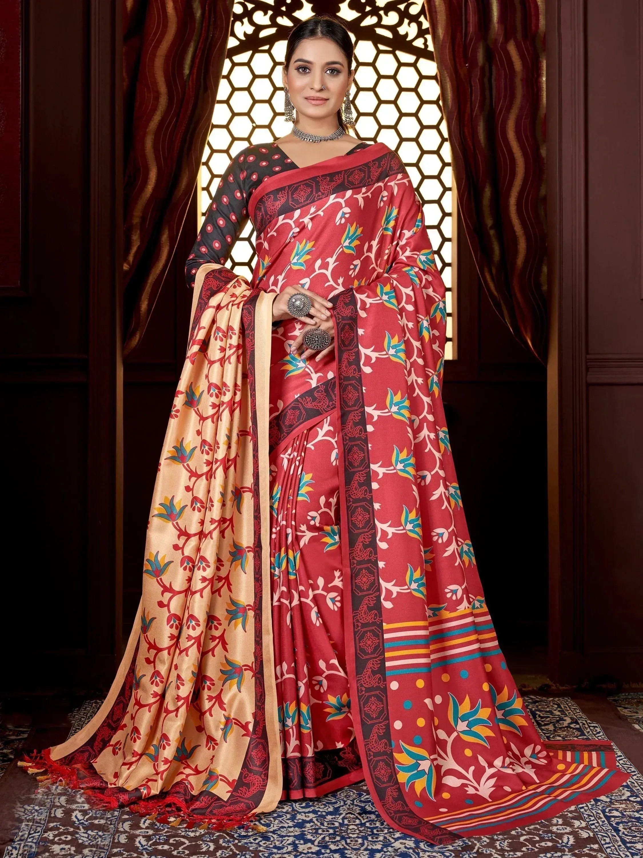 Red and gold printed saree with floral motifs, paired with black blouse, ideal for Indian ethnic wear occasions