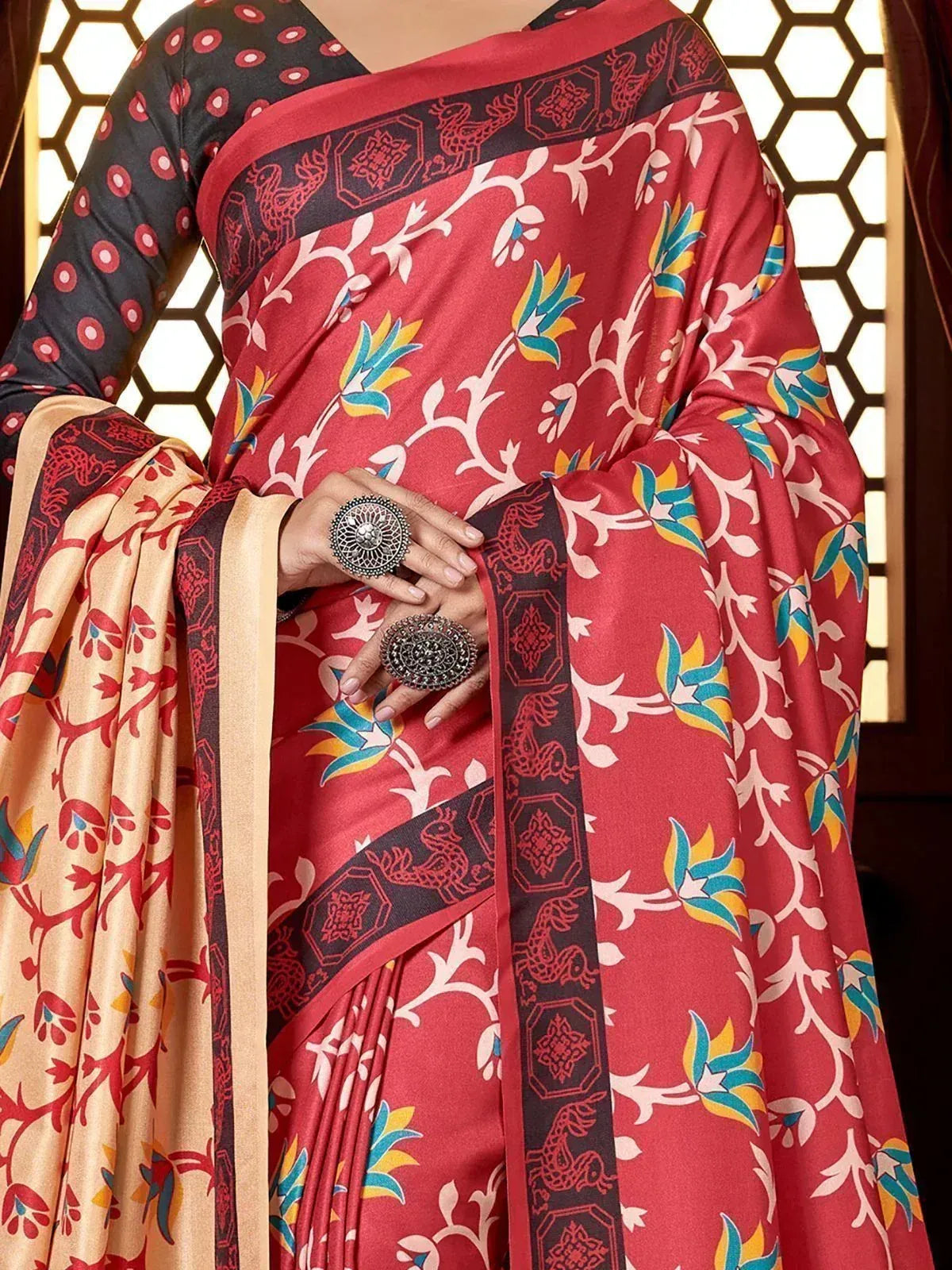 Red printed saree with floral and deer motifs, paired with black polka dot blouse, ethnic Indian wear