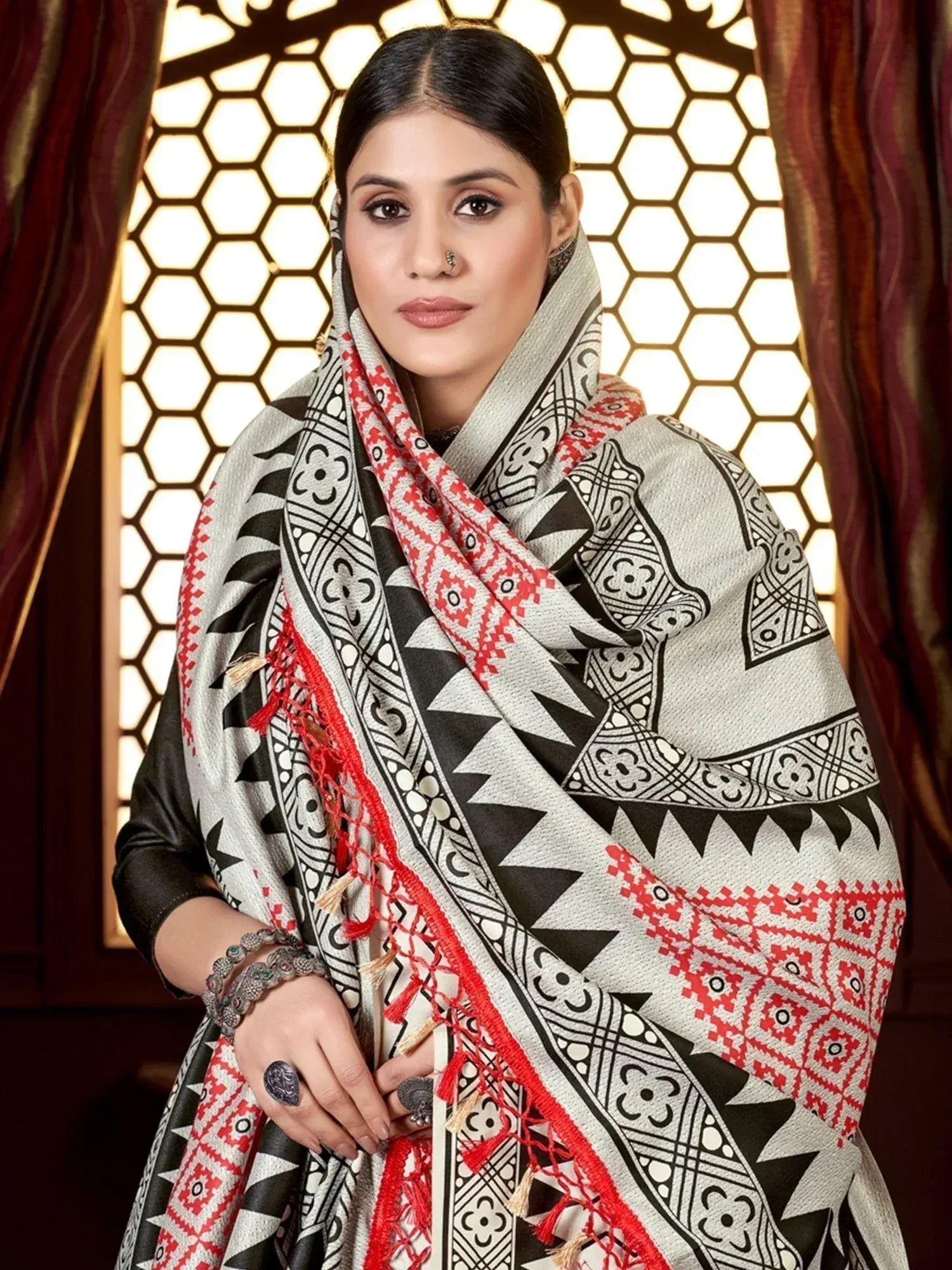 Woman in ethnic Indian outfit with black, white, and red geometric dupatta, styled for festive occasions.