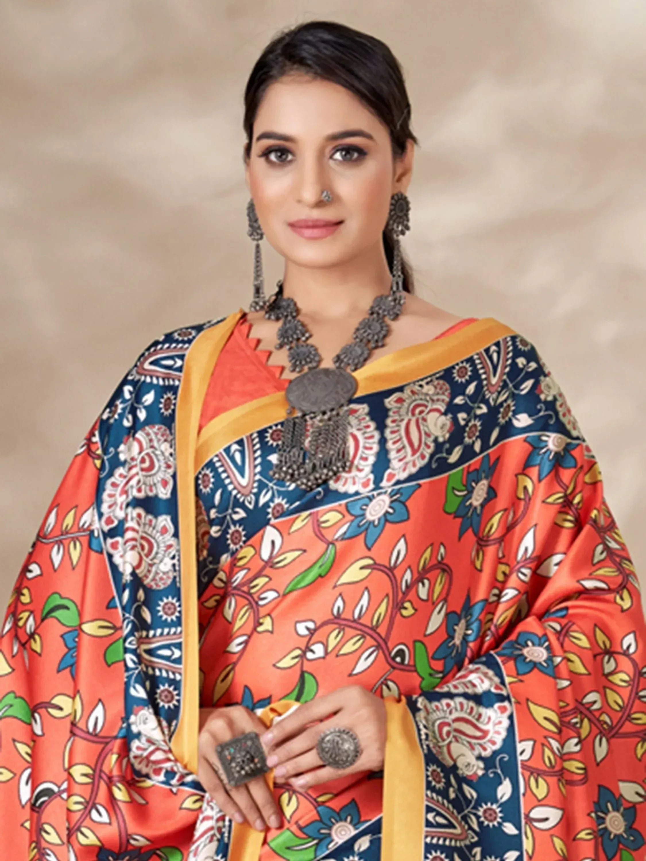 Woman in vibrant orange and blue printed Indian ethnic salwar kameez with floral patterns and traditional jewelry