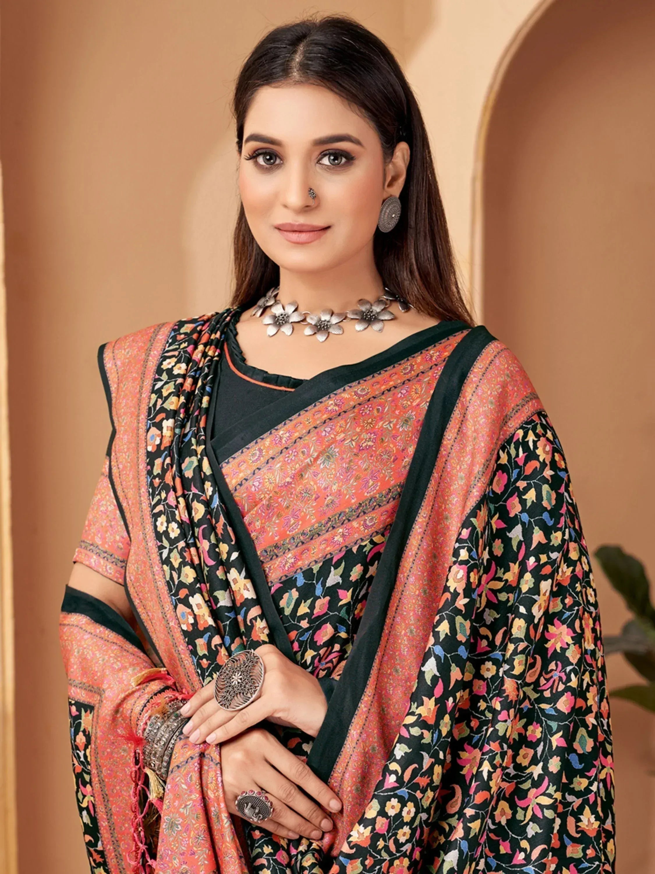 Elegant black and orange floral saree with intricate embroidery and traditional jewelry