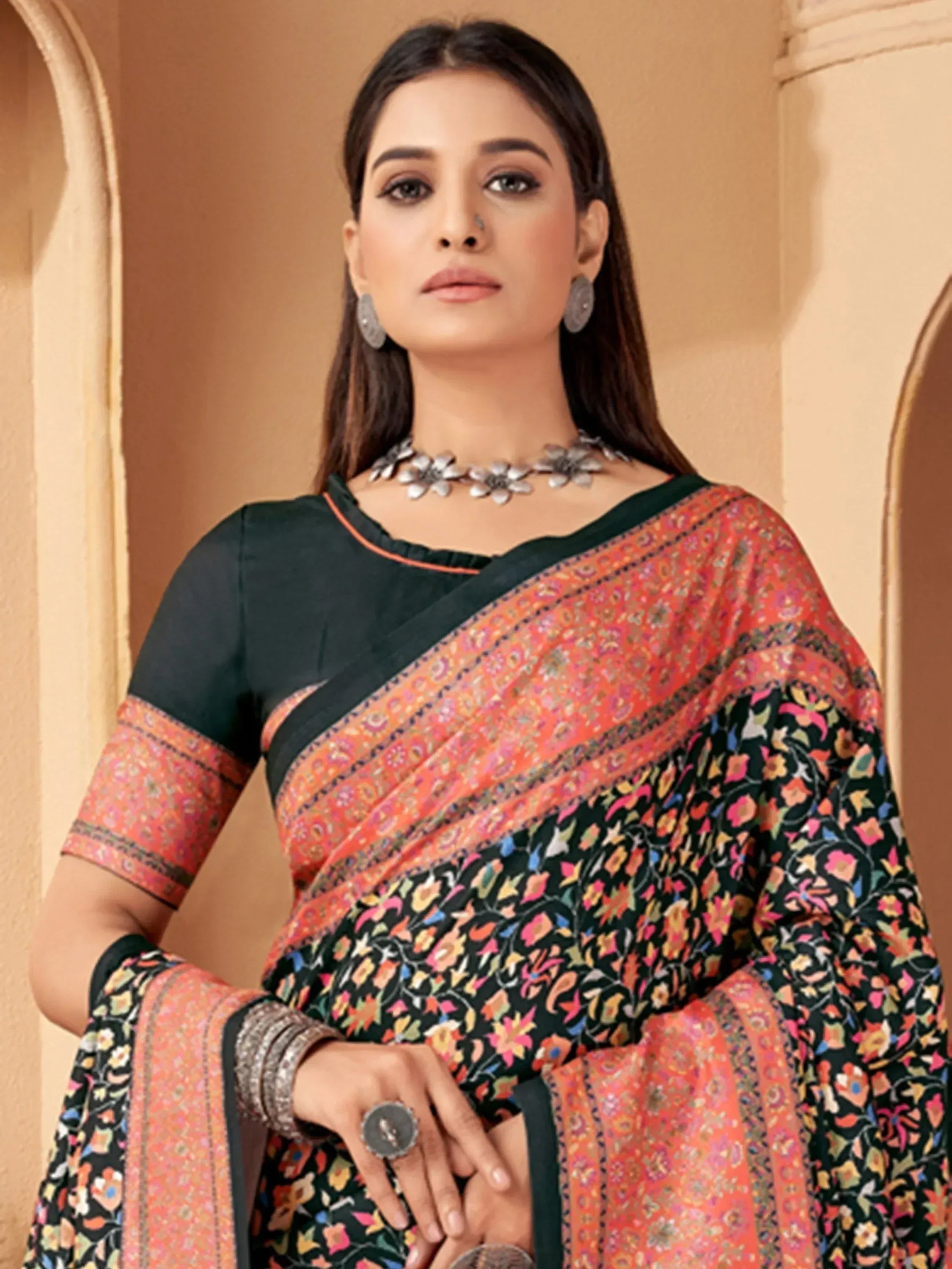 Woman in black and orange floral printed saree with matching blouse, ethnic jewelry, traditional Indian wear