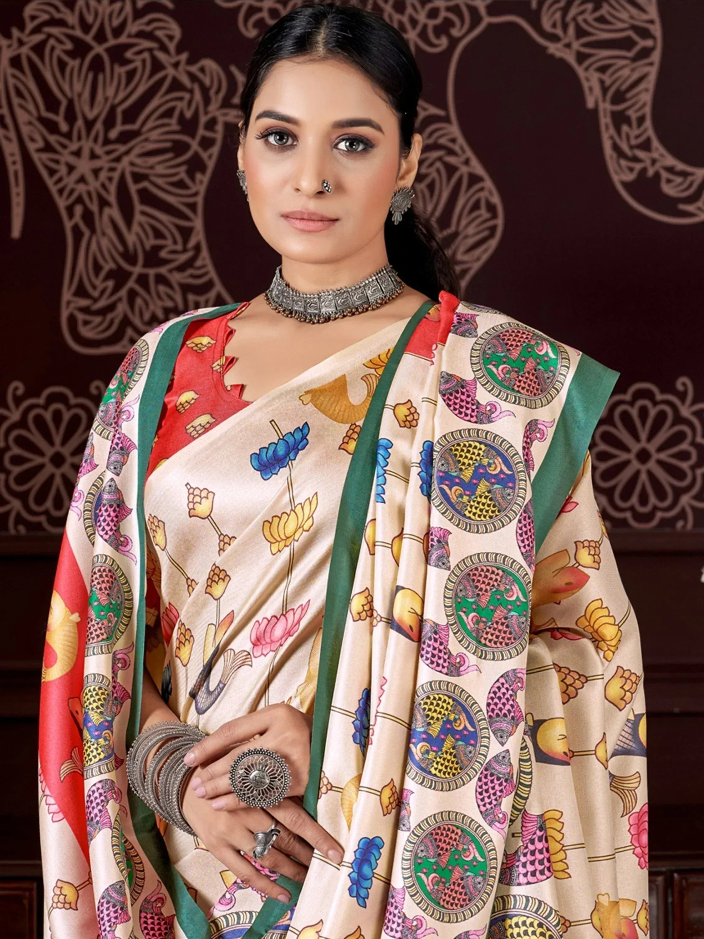 Elegant Indian saree with floral and fish motifs, paired with traditional jewelry for festive occasions.