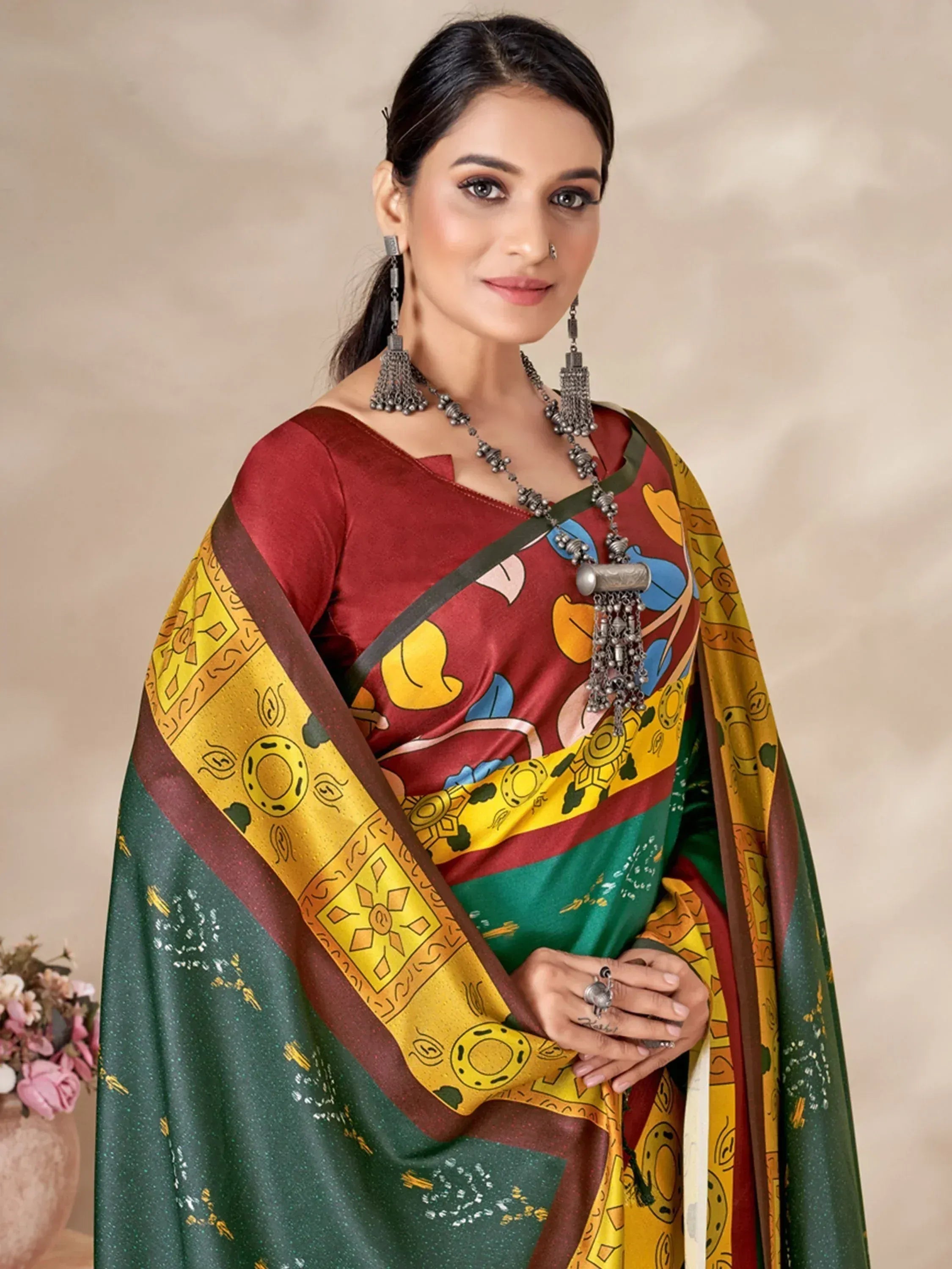 Woman in colorful printed saree with ethnic jewelry, maroon blouse, and green-yellow border design