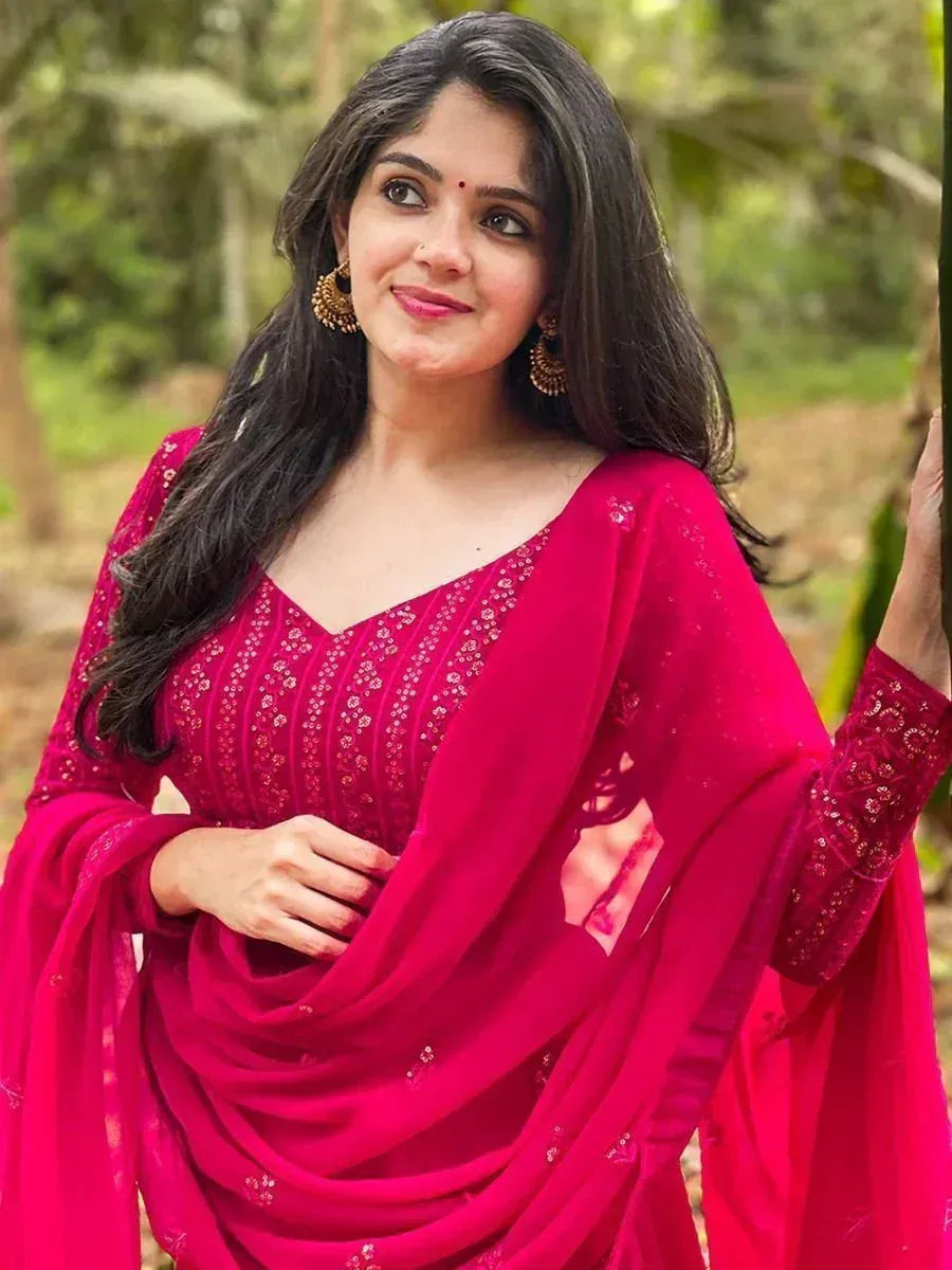 Woman in vibrant pink embroidered salwar kameez with matching dupatta, perfect for Indian ethnic occasions